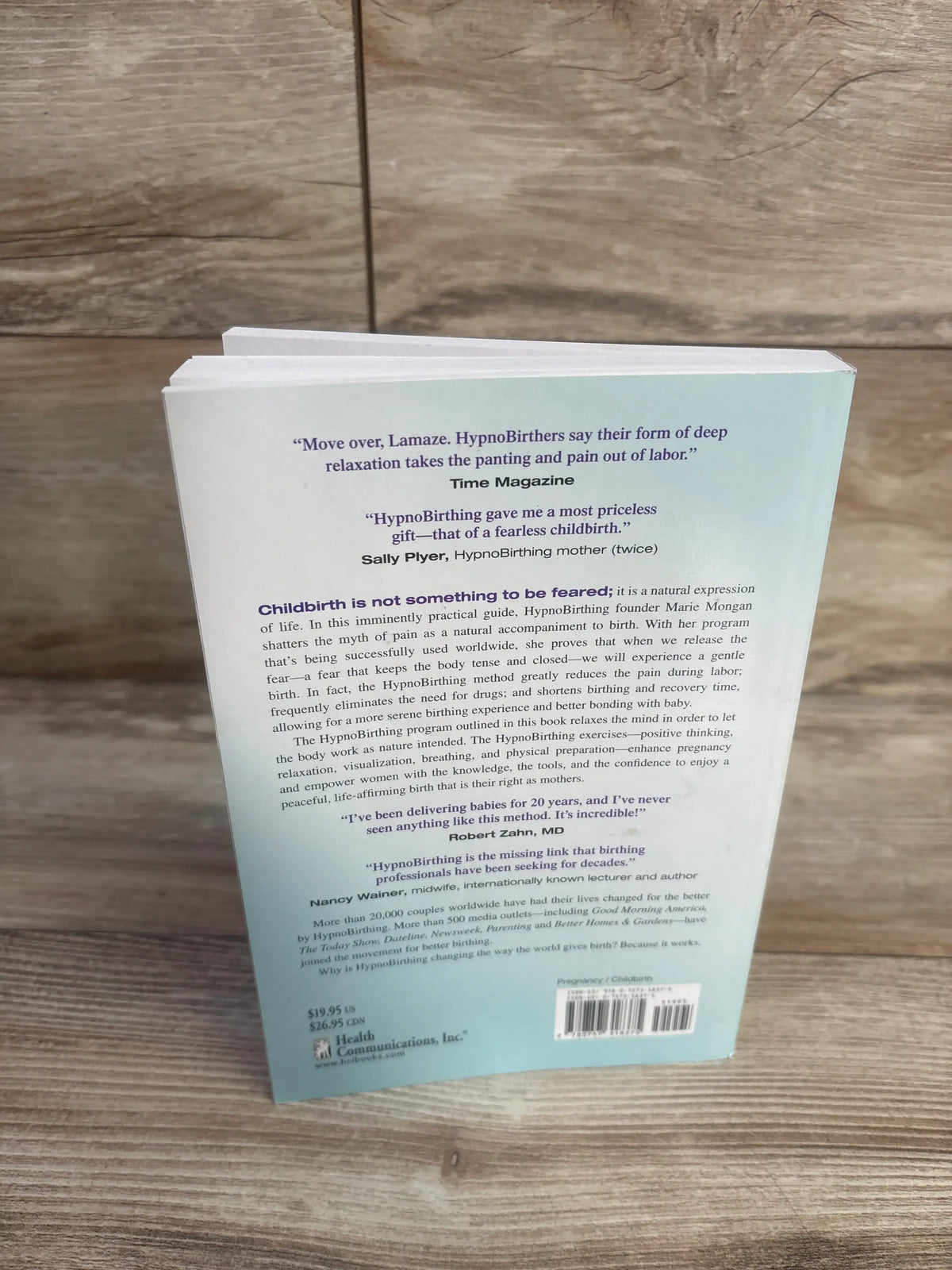 Back cover of HypnoBirthing paperback book showcasing childbirth relaxation guidance with wood-grain background