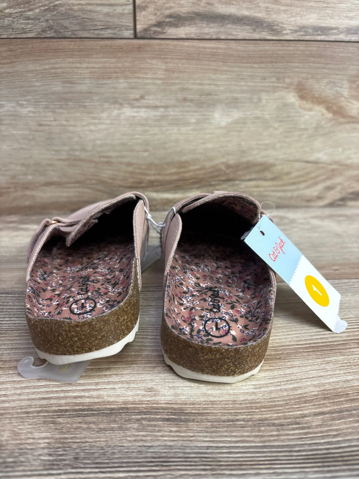 Three-quarter view of Cat and Jack Perry toddler clogs in blush with adjustable buckle and cork-look sole on wooden floor