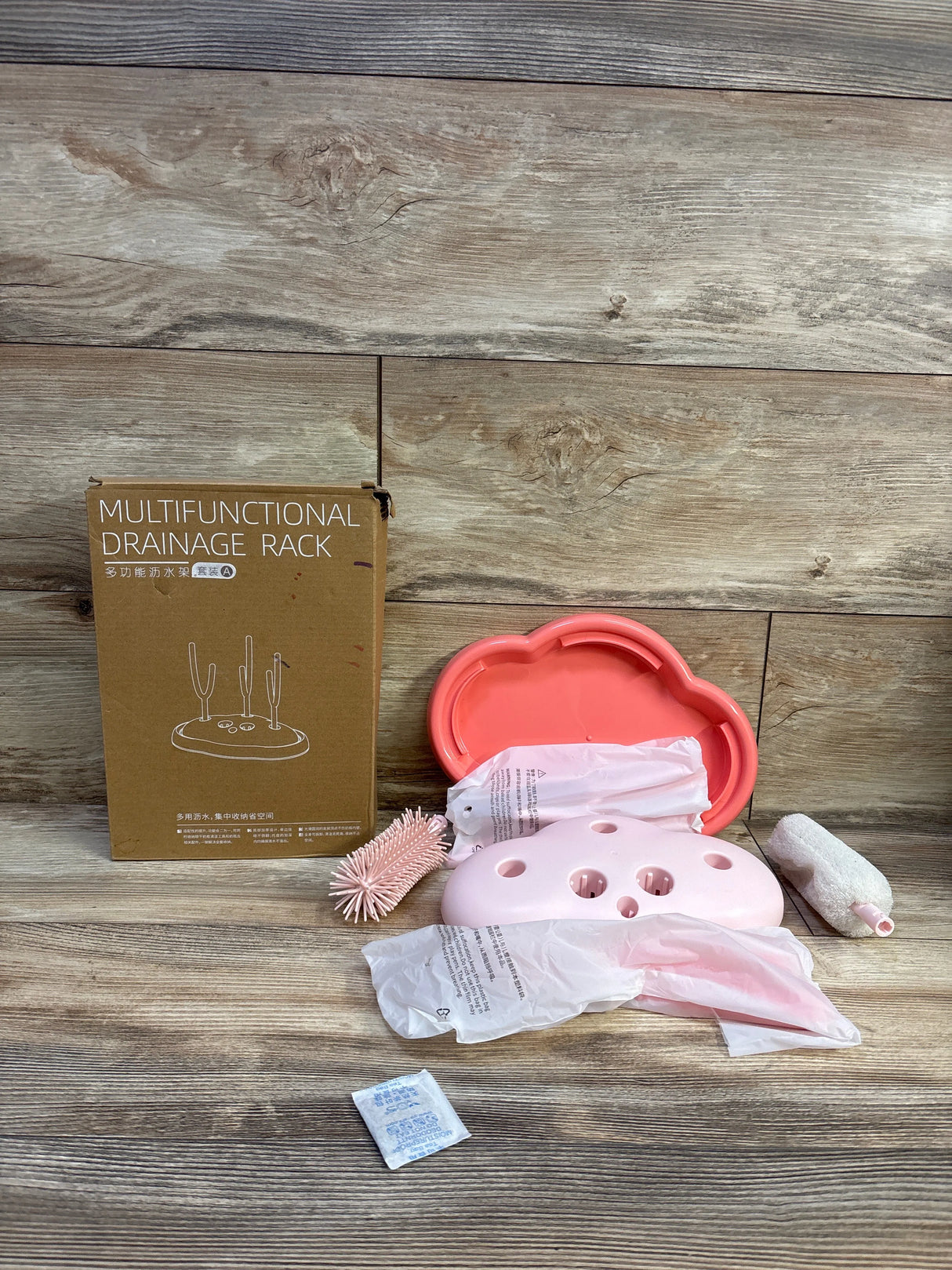 Front view of pink Voowo baby bottle brush and disassembled drying rack with cloud shaped tray and packaging