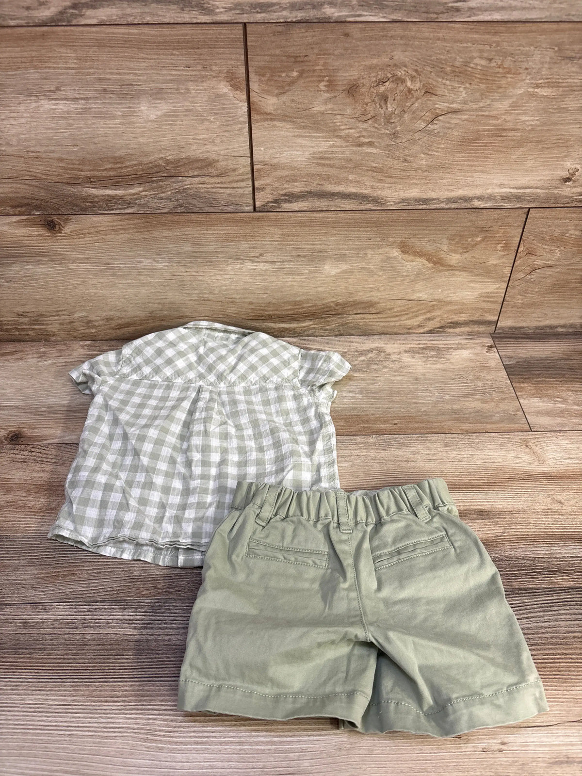 Top-down view of green Haute Hippie button-up shirt and shorts set with checked shirt and elastic-waist shorts on wood flooring