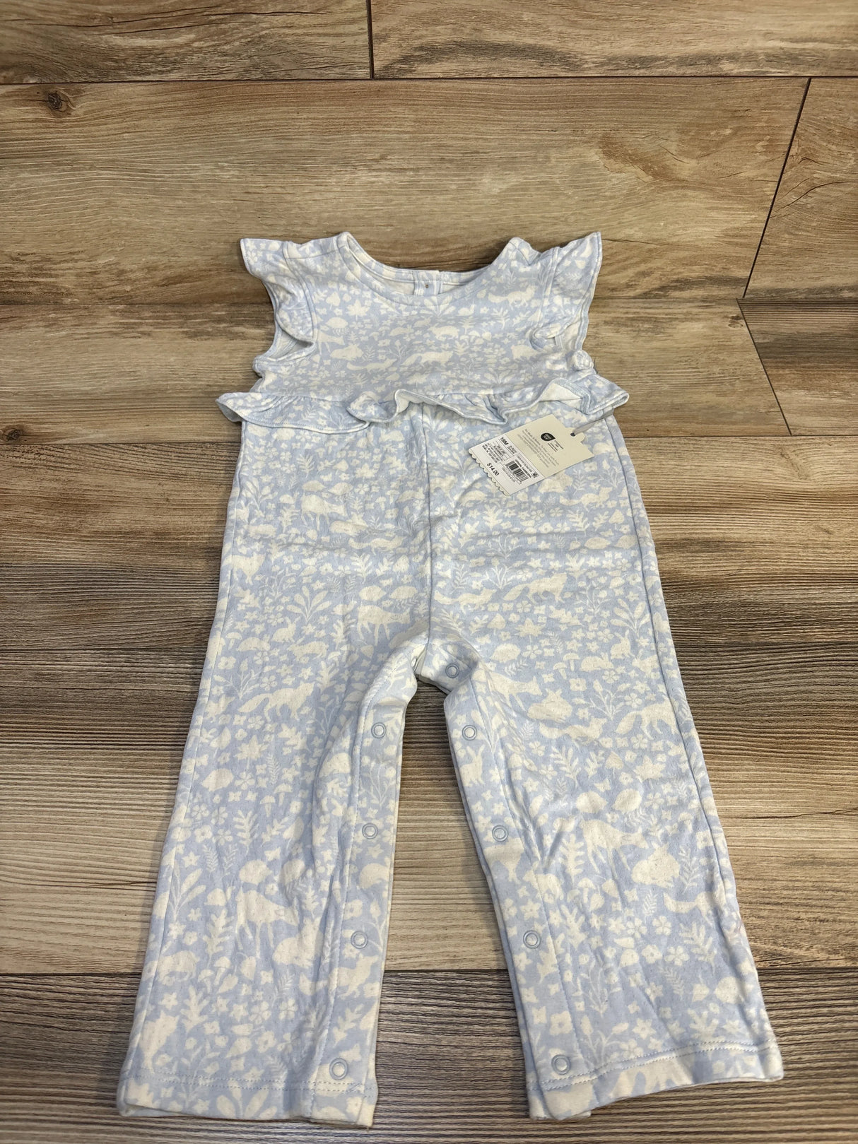 Light blue baby romper with white floral print, ruffle sleeves, and snap closures