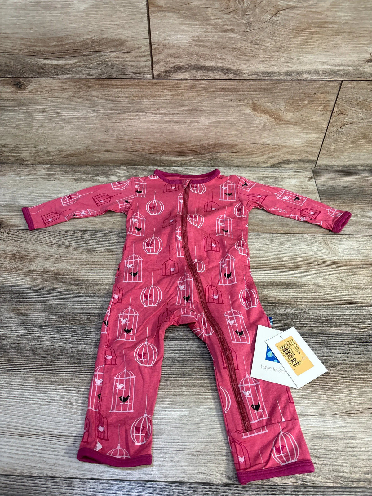 Front view of KicKee Pants Winter Rose Birdcage Pink coverall showing birdcage print and full zip closure on wood flooring