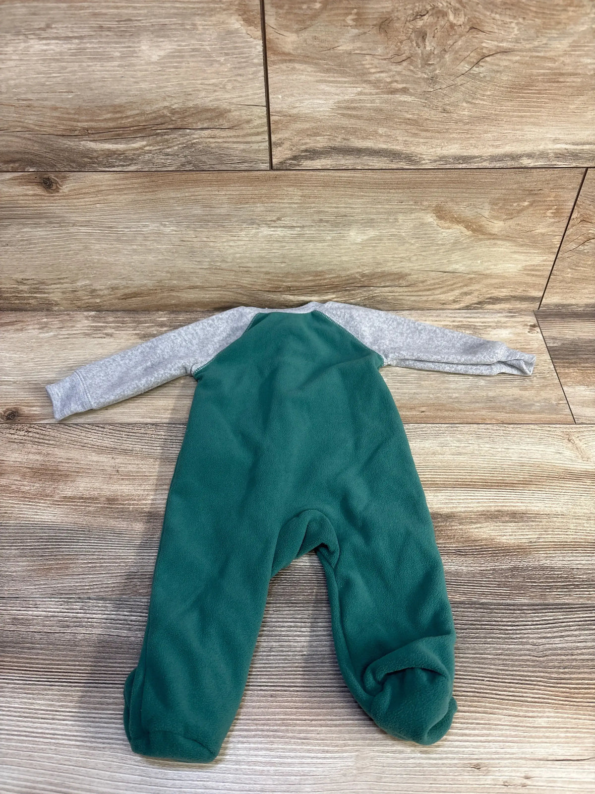 Back view of Carter's blanket sleeper: green fleece body, heather grey sleeves, built-in feet, laid flat on wood background
