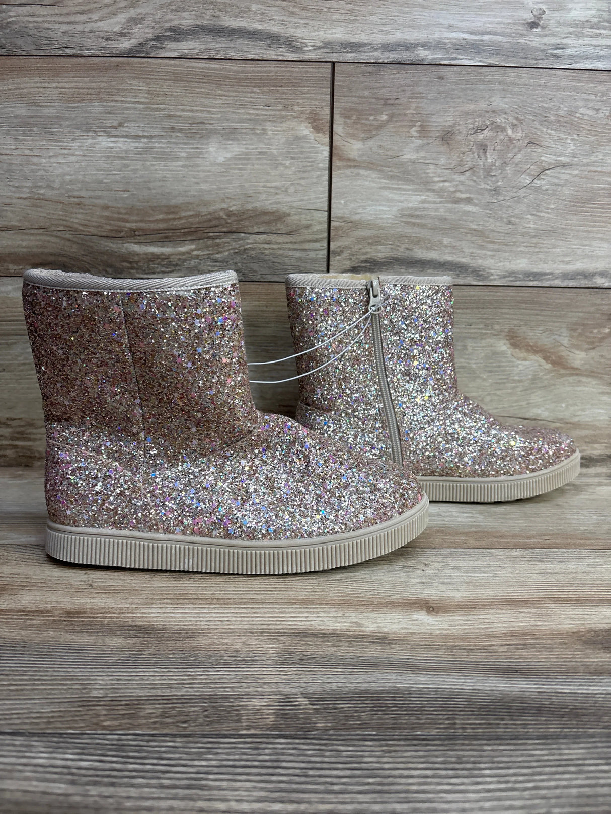 Sparkly pink glitter toddler boots with side zipper on wood floor
