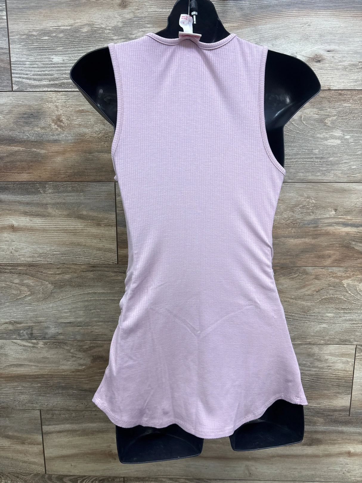 Sleeveless light purple ribbed dress for kids on black hanger, wooden background