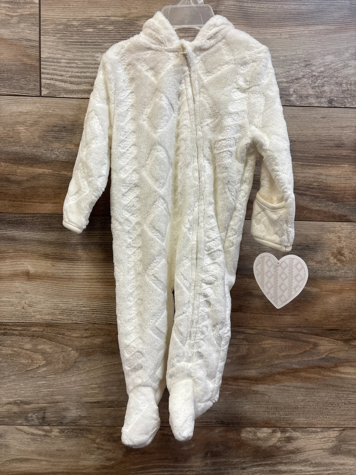 Front view of ivory plush bunting showcasing a hood, zip front, and enclosed feet on a wood background