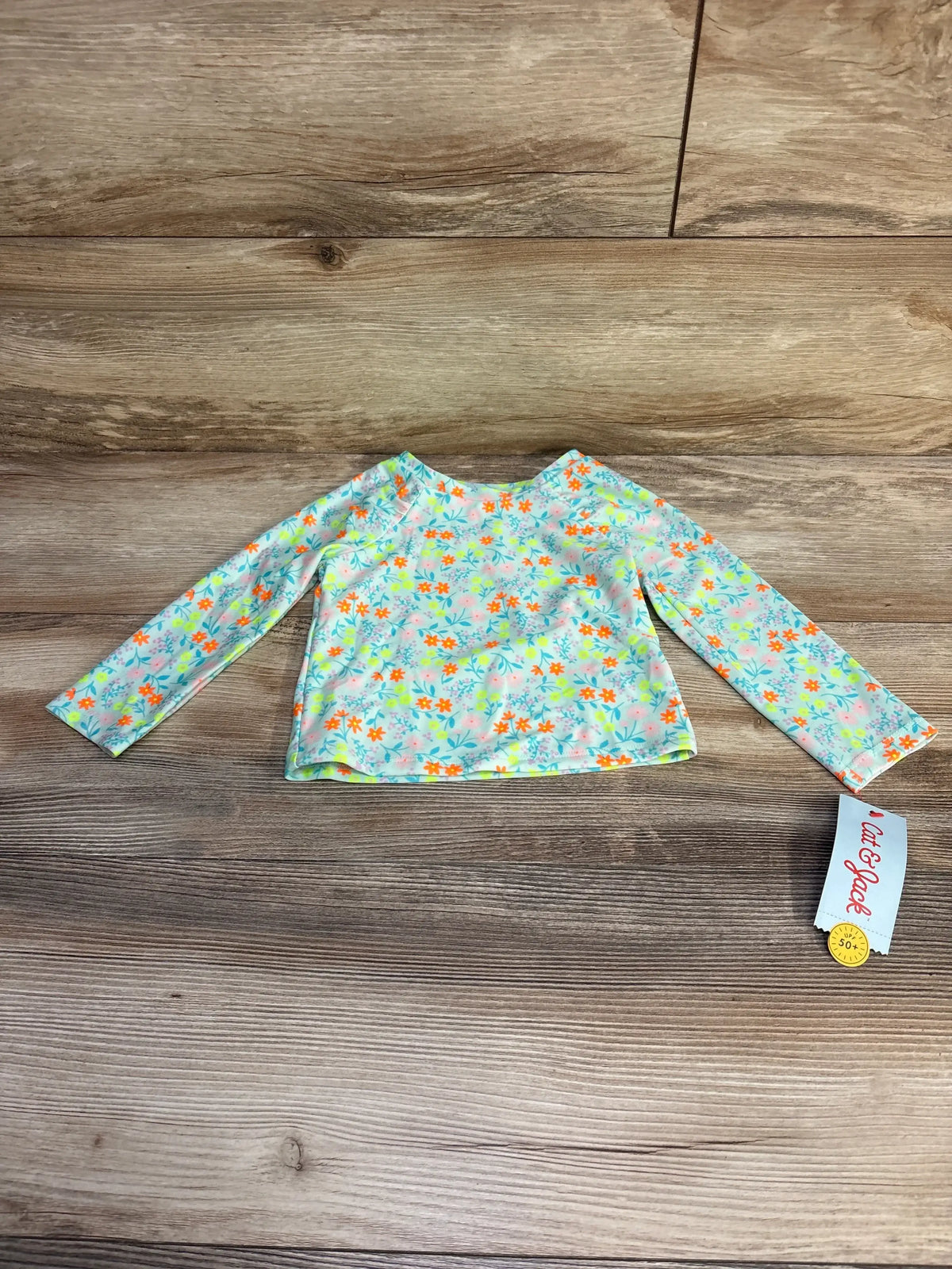 Front view of blue Cat & Jack toddler floral long-sleeve rashguard top size 2T showcasing all-over floral print and high neckline on white background