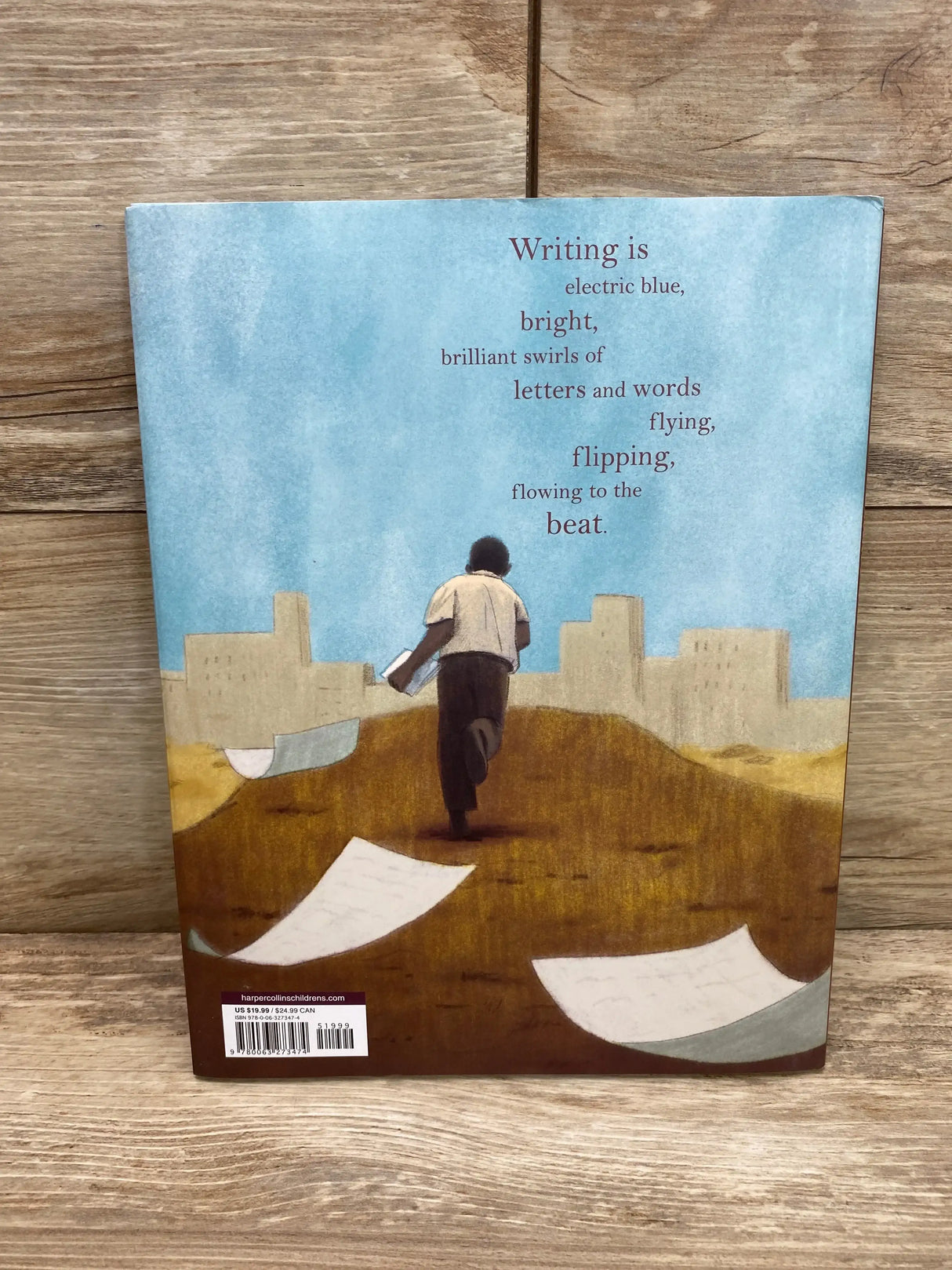 Back cover of Jimmy’s Rhythm & Blues hardcover showcasing an illustration of a boy walking with loose papers and the verse ‘Writing is electric blue...flowing to the beat’