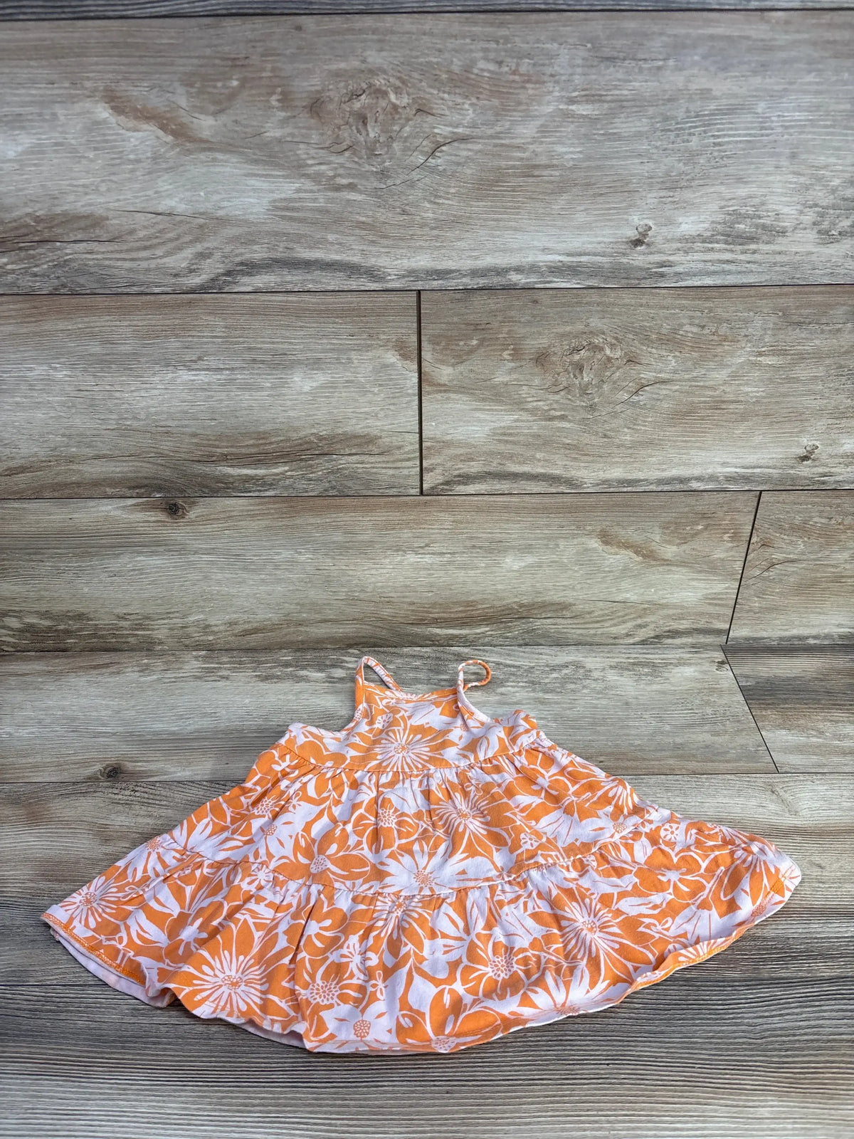 Front view of Cat & Jack orange tank dress in size 18m showcasing floral print and tiered skirt on a wood-look floor