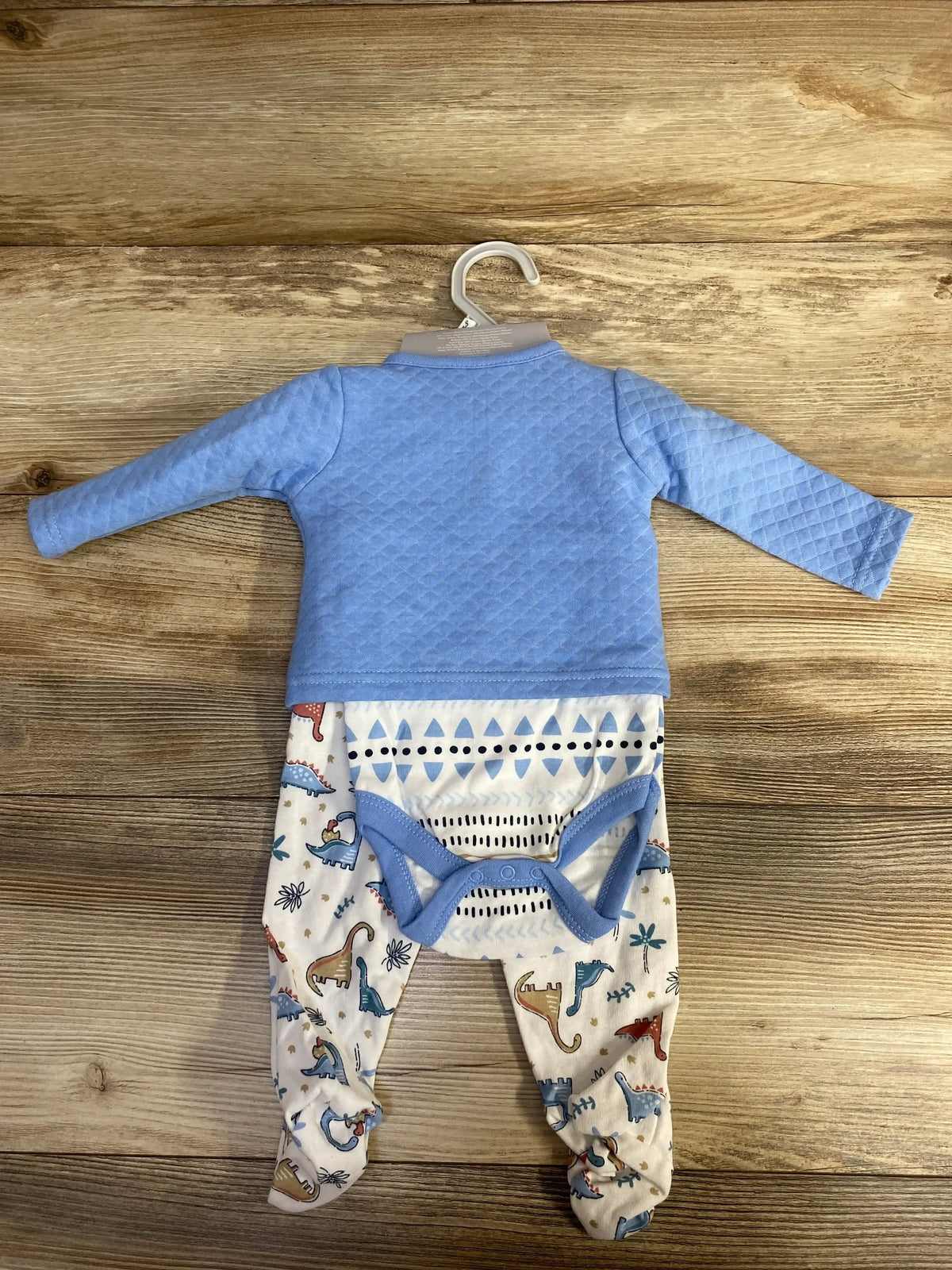 Front view of NEW Le Top Bebe 4pc Set showcasing blue quilted shirt, dinosaur print leggings, and bloomers on wood background