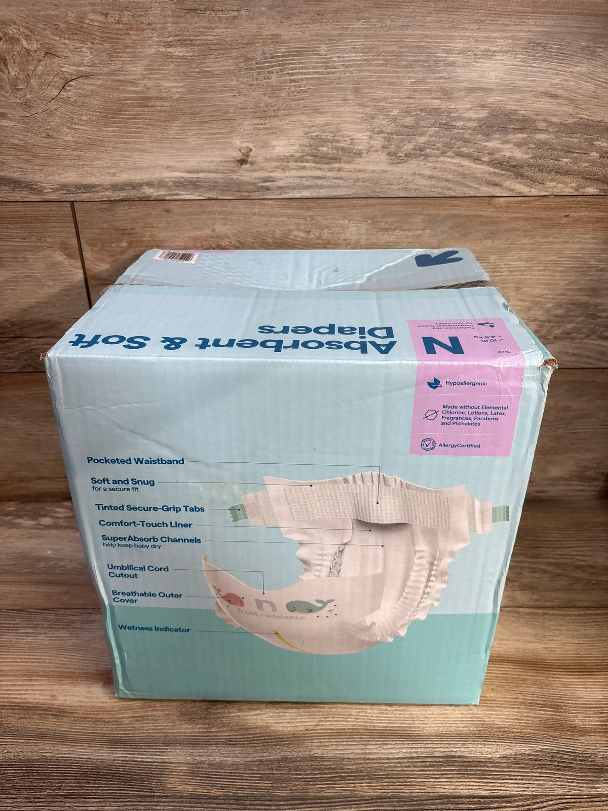 Three-quarter view of up&up newborn diaper 162-count box with feature callouts on wooden surface