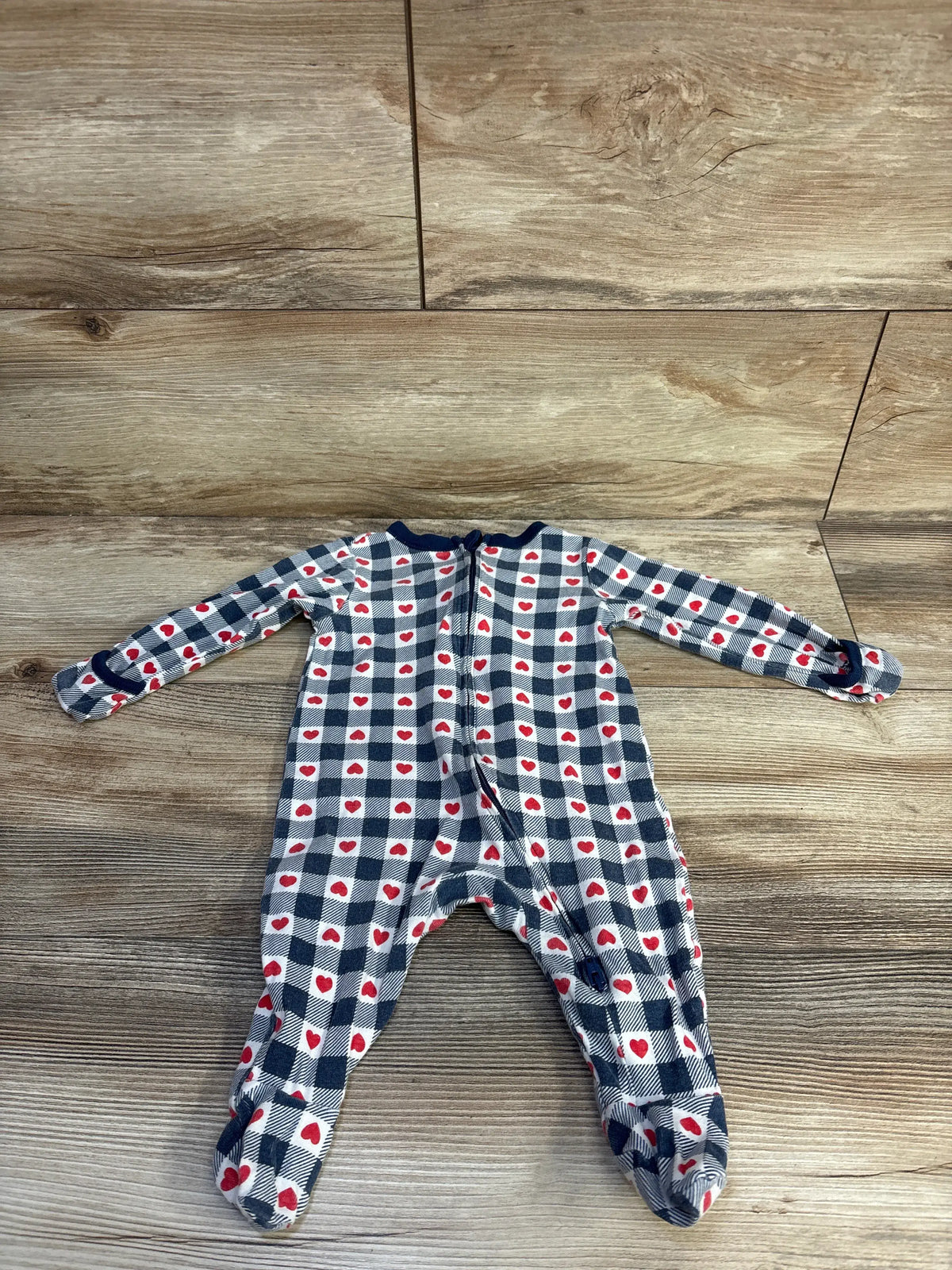 Front view of Old Navy blue and white checked heart sleeper with long sleeves and two-way zipper on a woodgrain background