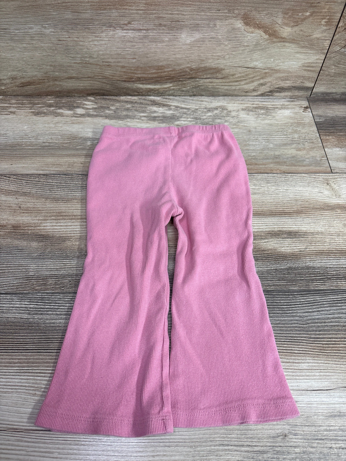 Baby Gap pink ribbed flare leggings for toddlers laid flat on a wooden surface