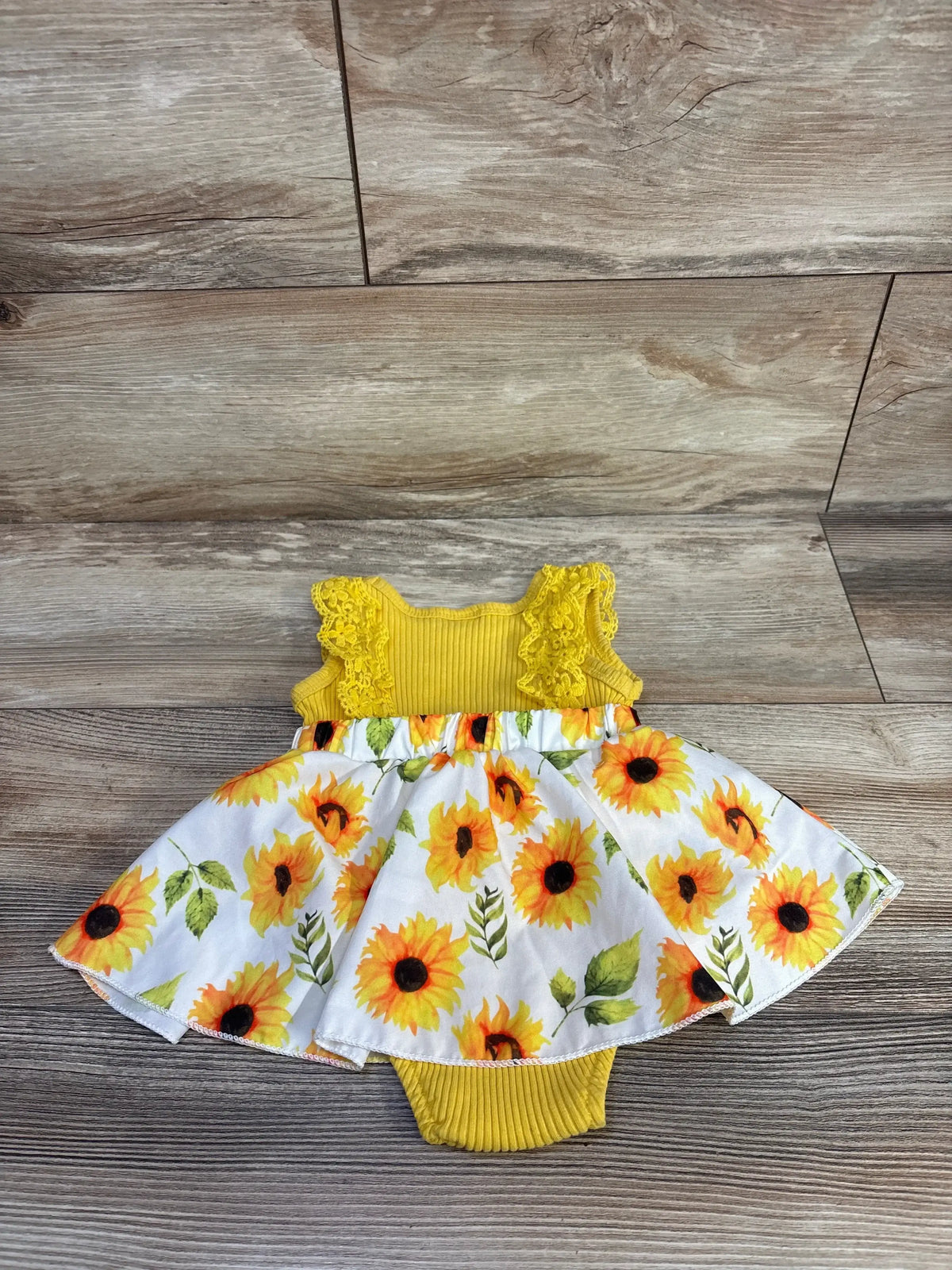 Front view of yellow WIBACKER floral ribbed bodysuit dress with lace detailing and sunflower print skirt on wood flooring