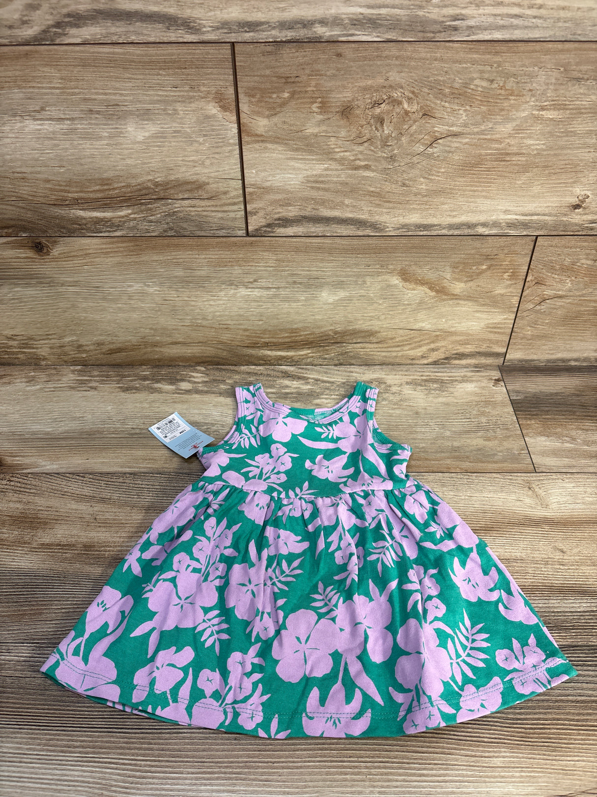 Flat lay of Cat and Jack teal sleeveless floral dress with matching bloomers showing pink flower print on wood floor