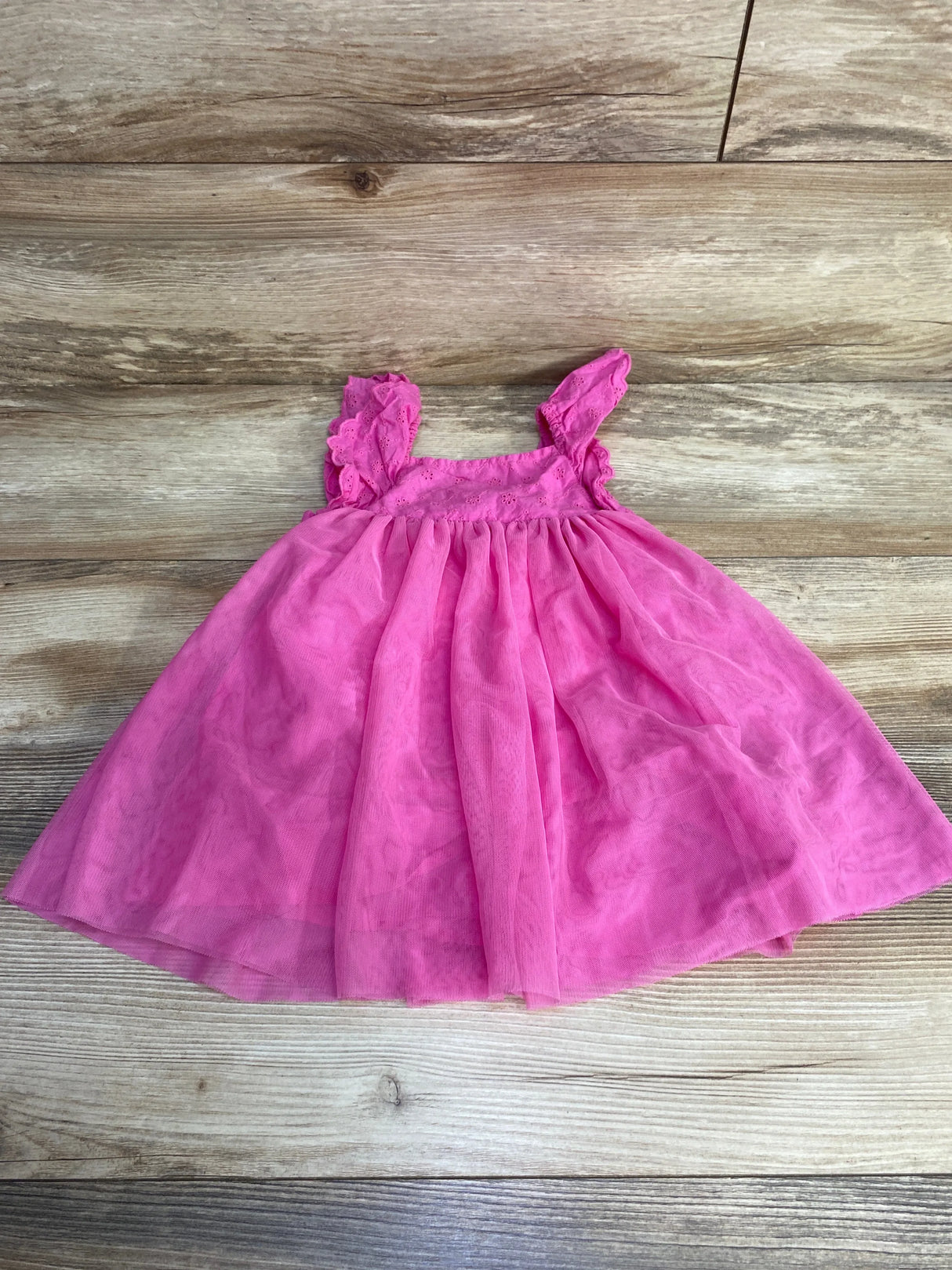 Flat-lay of pink Cat and Jack eyelet tulle dress size 18M showcasing eyelet bodice, ruffled straps and tulle skirt on wood floor
