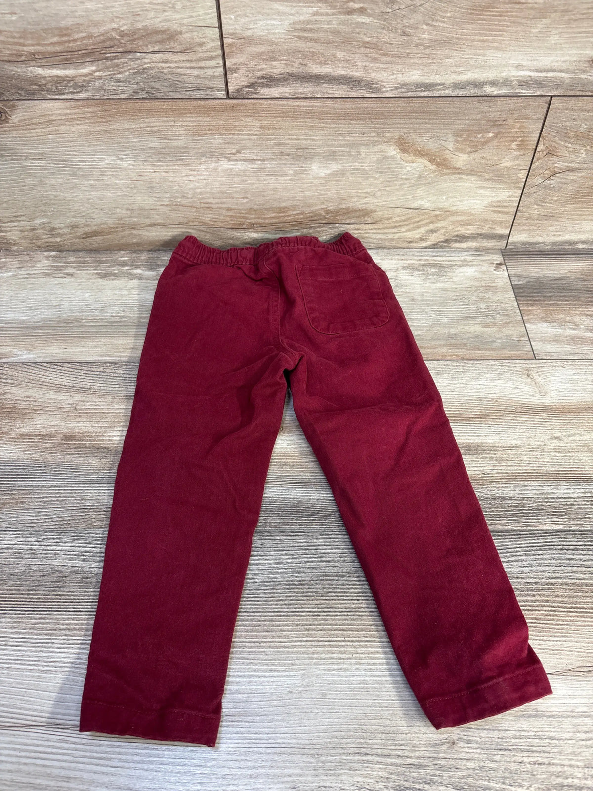 Front view of red Cat & Jack drawstring joggers in size 3T showcasing tapered legs and pockets on a wood-look floor