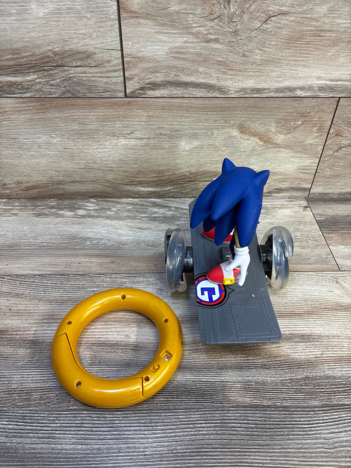 Sonic the Hedgehog toy figure on a wheeled platform with a large yellow plastic ring