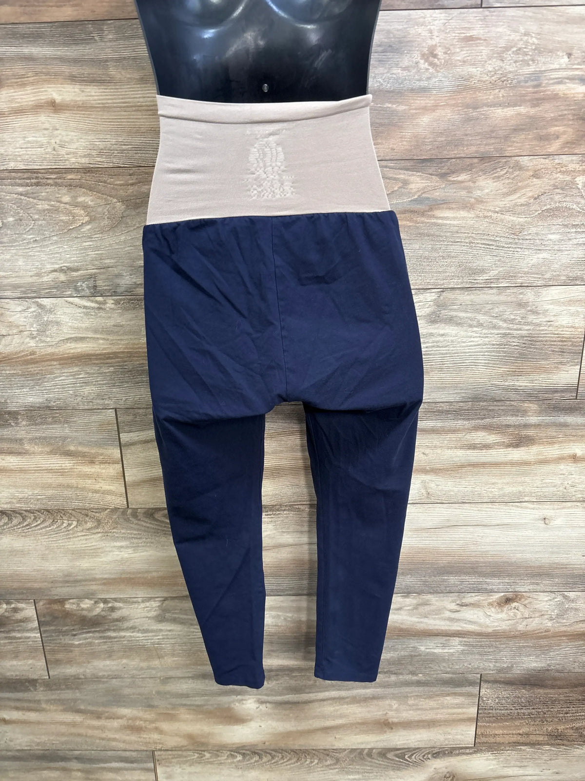 Front view of Motherhood Maternity full panel leggings in navy, size Medium, showing the full belly panel on a wood floor