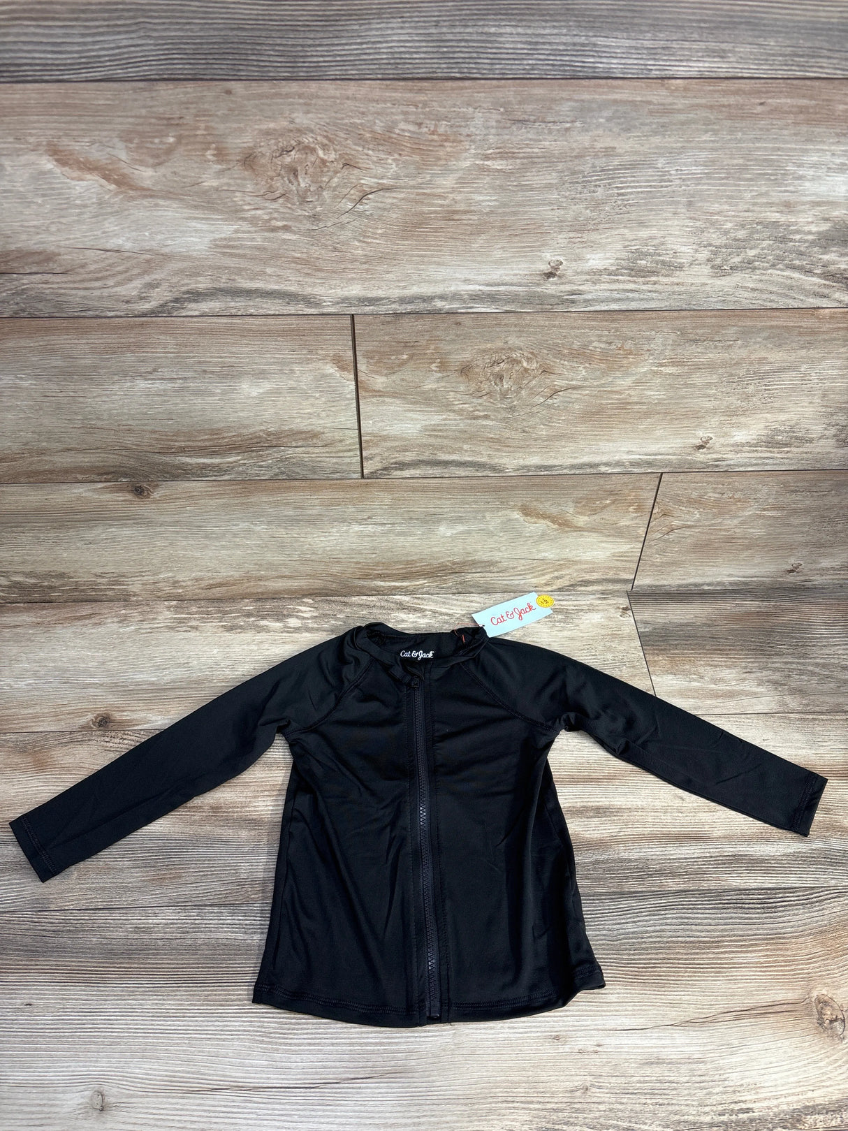 Black long-sleeve zip-up shirt for kids by Cat & Jack on wooden background