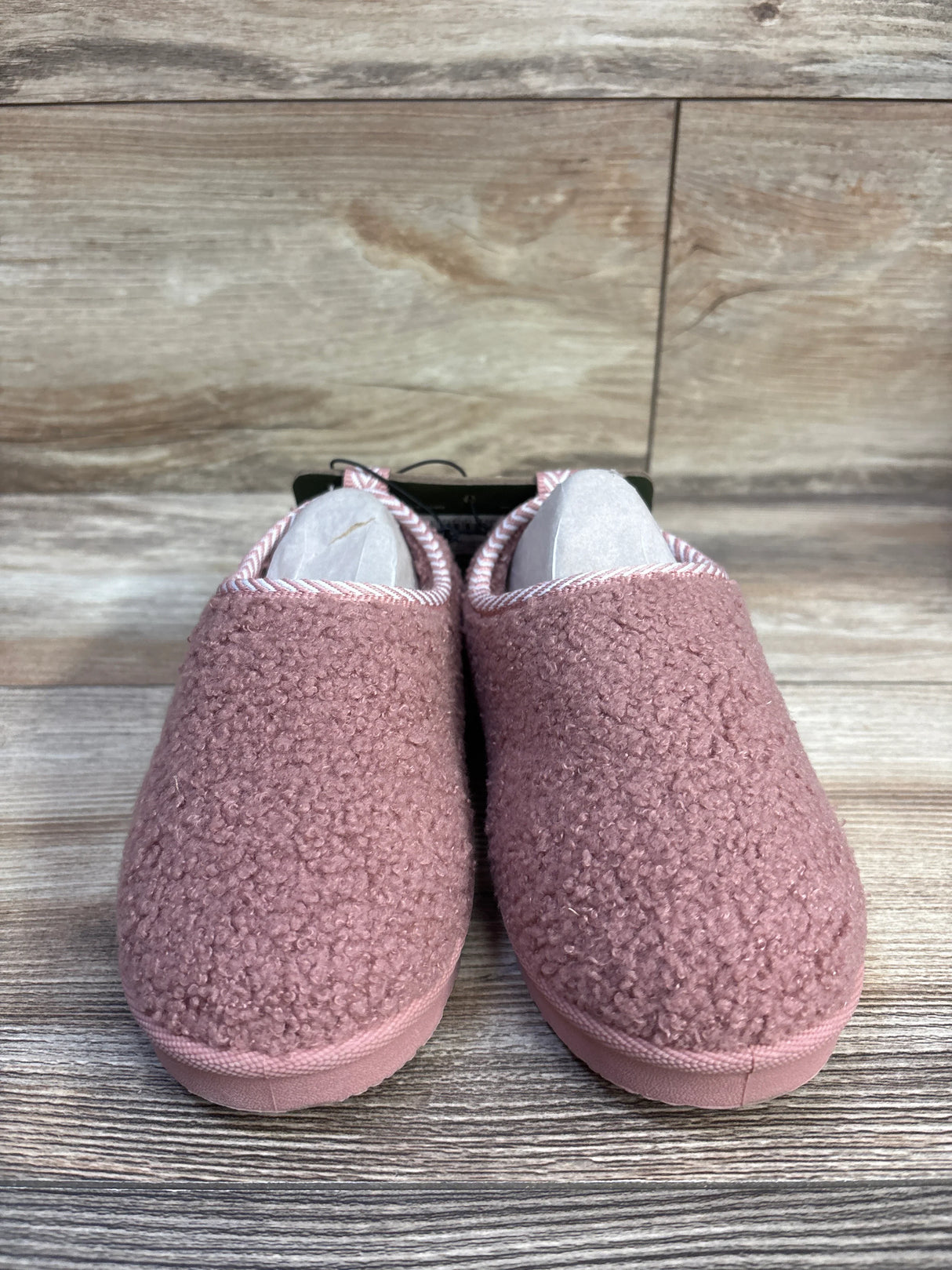 Front view of Pawz Cozy toddler slippers size 11/12C showcasing plush pink sherpa texture and rubber soles on wood background