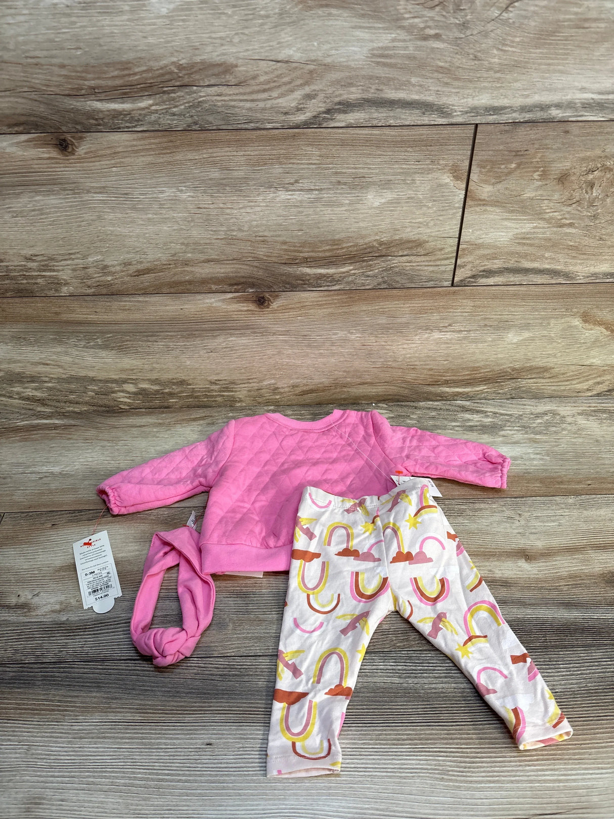 Baby girl outfit with pink quilted sweatshirt, rainbow leggings, and matching headband