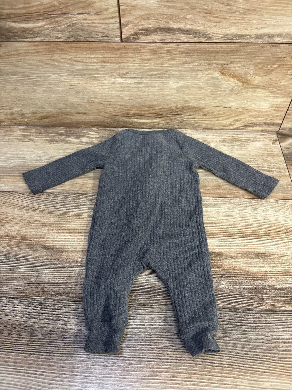 Front view of Cloud Island ribbed ruffle sleeper in soft grey showcasing ribbed fabric and long sleeves on a wood floor