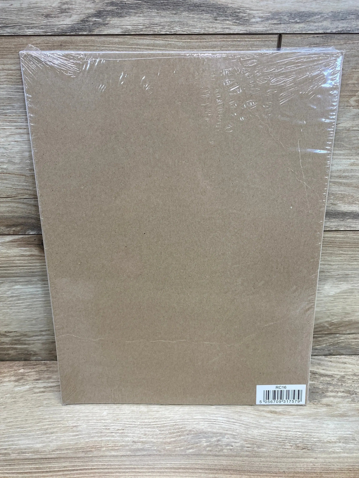 Back of reward chart with brown cardboard wrapped in clear plastic and barcode sticker lower right on wood backdrop
