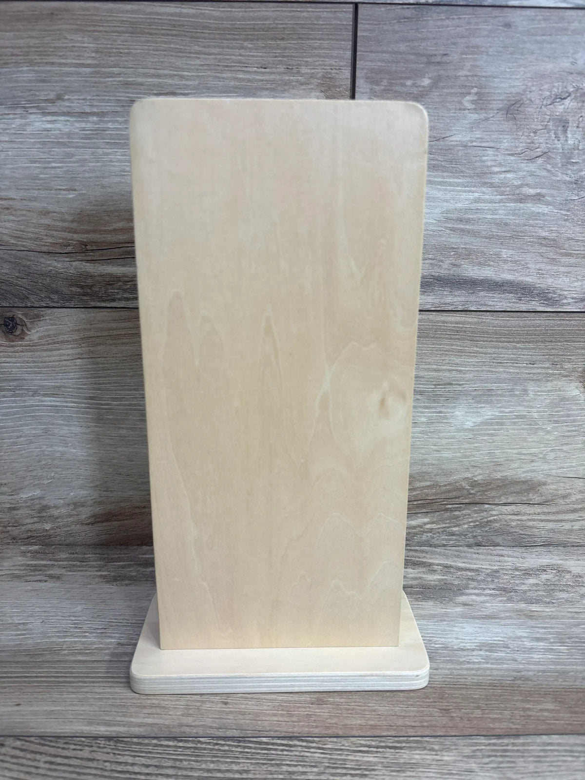 Rear view of KiwiCo Star Drop Maze showcasing its unfinished wooden back and rectangular base on a wood background