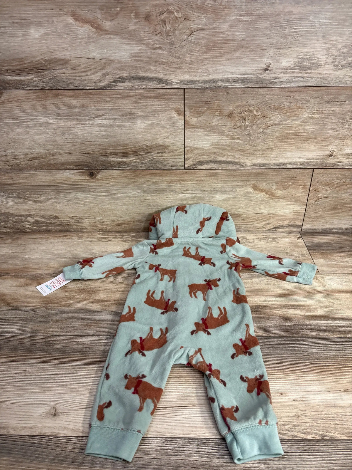 Baby reindeer print onesie, soft mint green with brown moose, Carter's brand, laid on wood floor