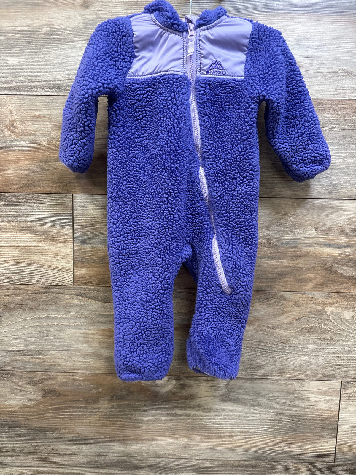 Purple Snozu sherpa hooded bunting baby sleepsuit on a wooden background