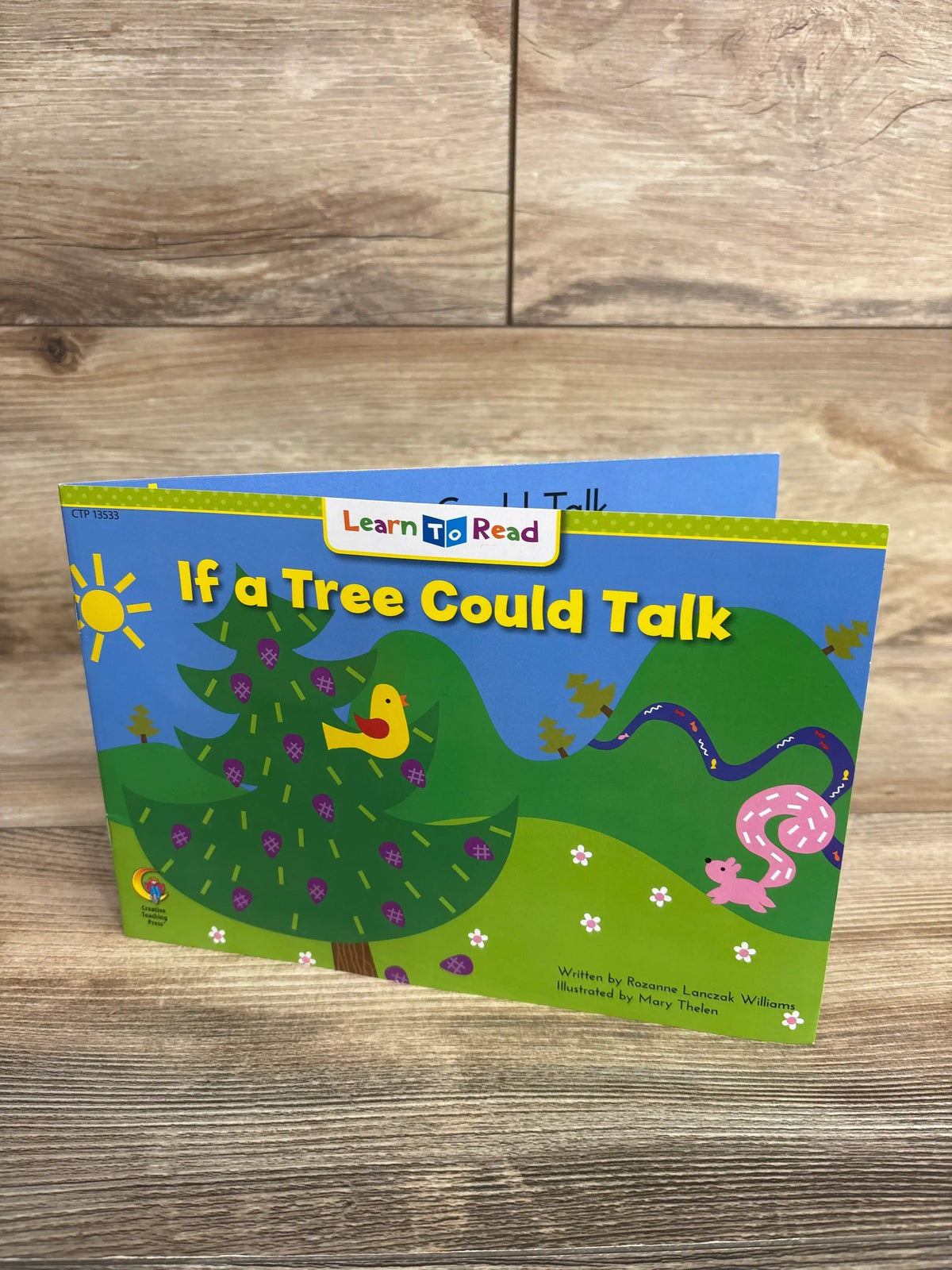 Children's book titled 'If a Tree Could Talk' with colorful tree, sun, bird, hills, and squirrel illustrations