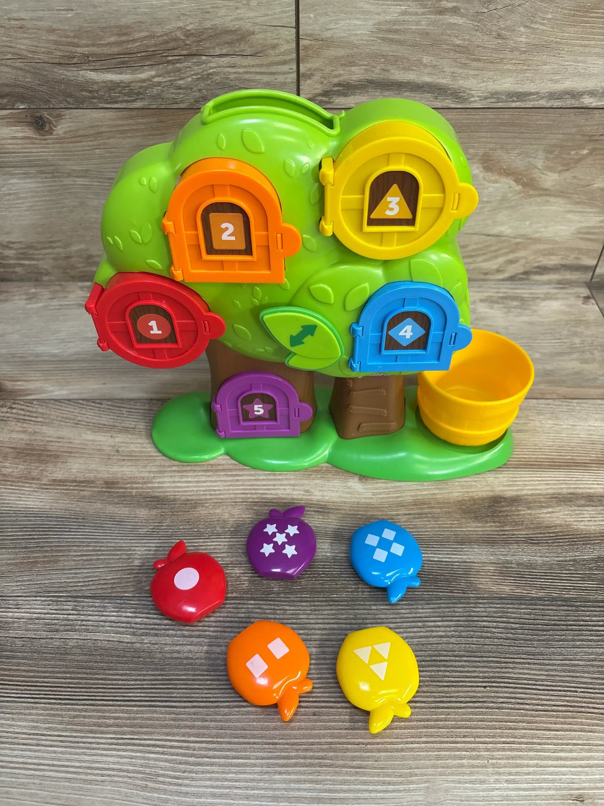 Front view of Learning Resources Hide & Seek Learning Treehouse showcasing five numbered doors and five shape apples