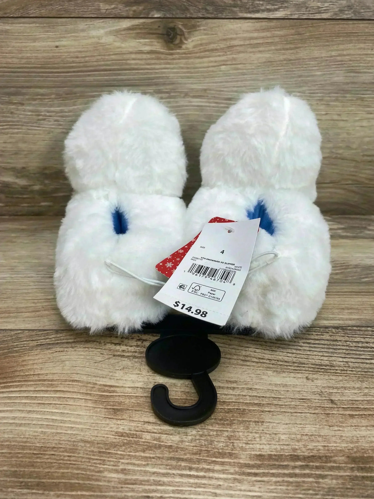 Pair of white Bumble Abominable Snowman baby slippers with plush fur, blue inner detail and visible size 4C tag on wood floor