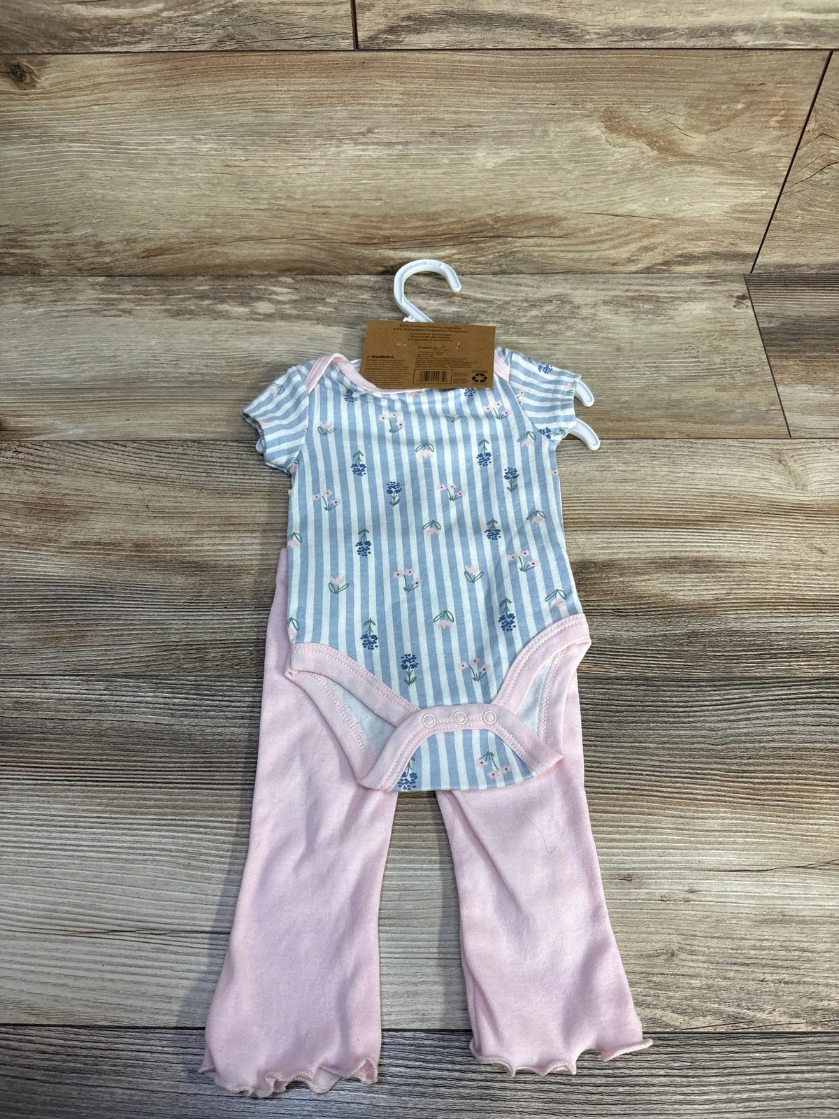 Front view of Dreamgro blue two piece set for 0 to 3 months, showing striped floral bodysuit and pants on wood flooring