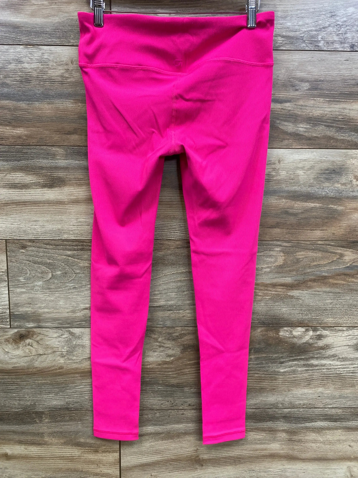 Back view of pink Gap Fit maternity leggings size small showing under-belly ribbed waistband and slim fit on wood background