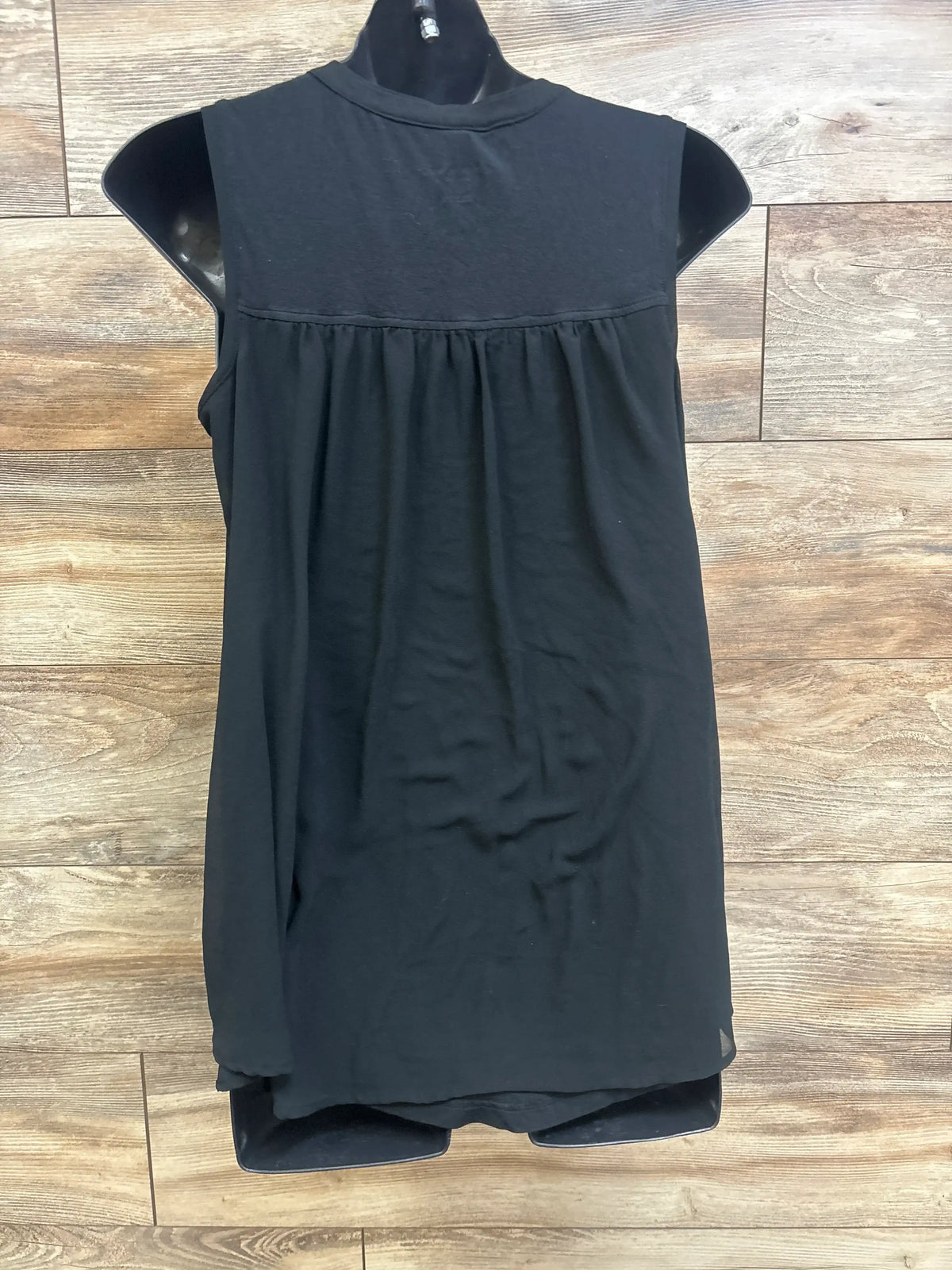 Back view of Liz Lange black sheer back tank top in size XS showcasing the sheer back panel on a wood-look floor