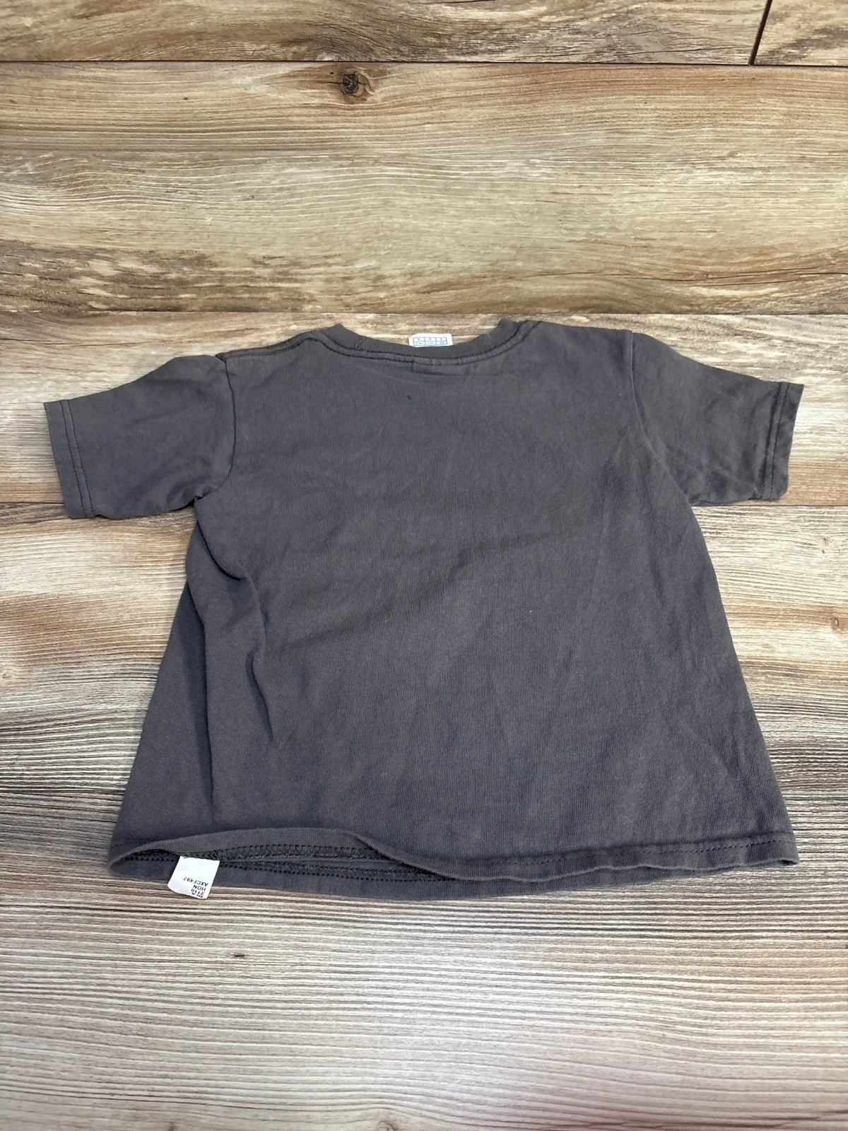 Back view of Delta Pro Weight tee showcasing solid gray short sleeve cotton on wood plank floor
