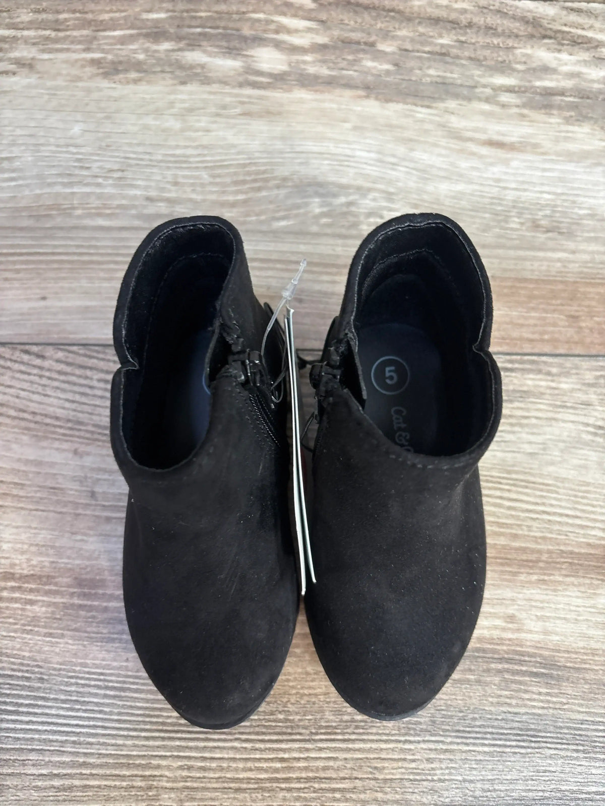 Black suede ankle boots size 5 on wood floor, side zipper, top view