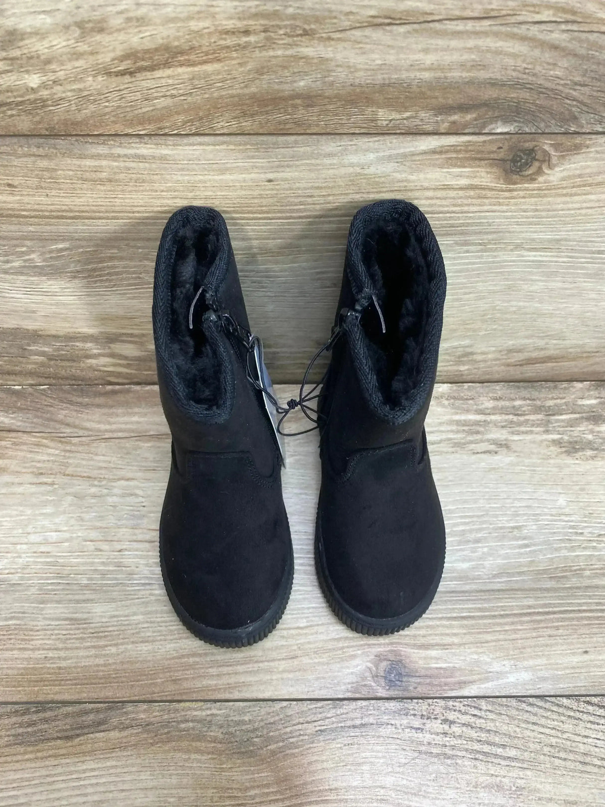 Top down view of toddler Cat and Jack black shearling style zipper boots showing faux fur lining on wood floor