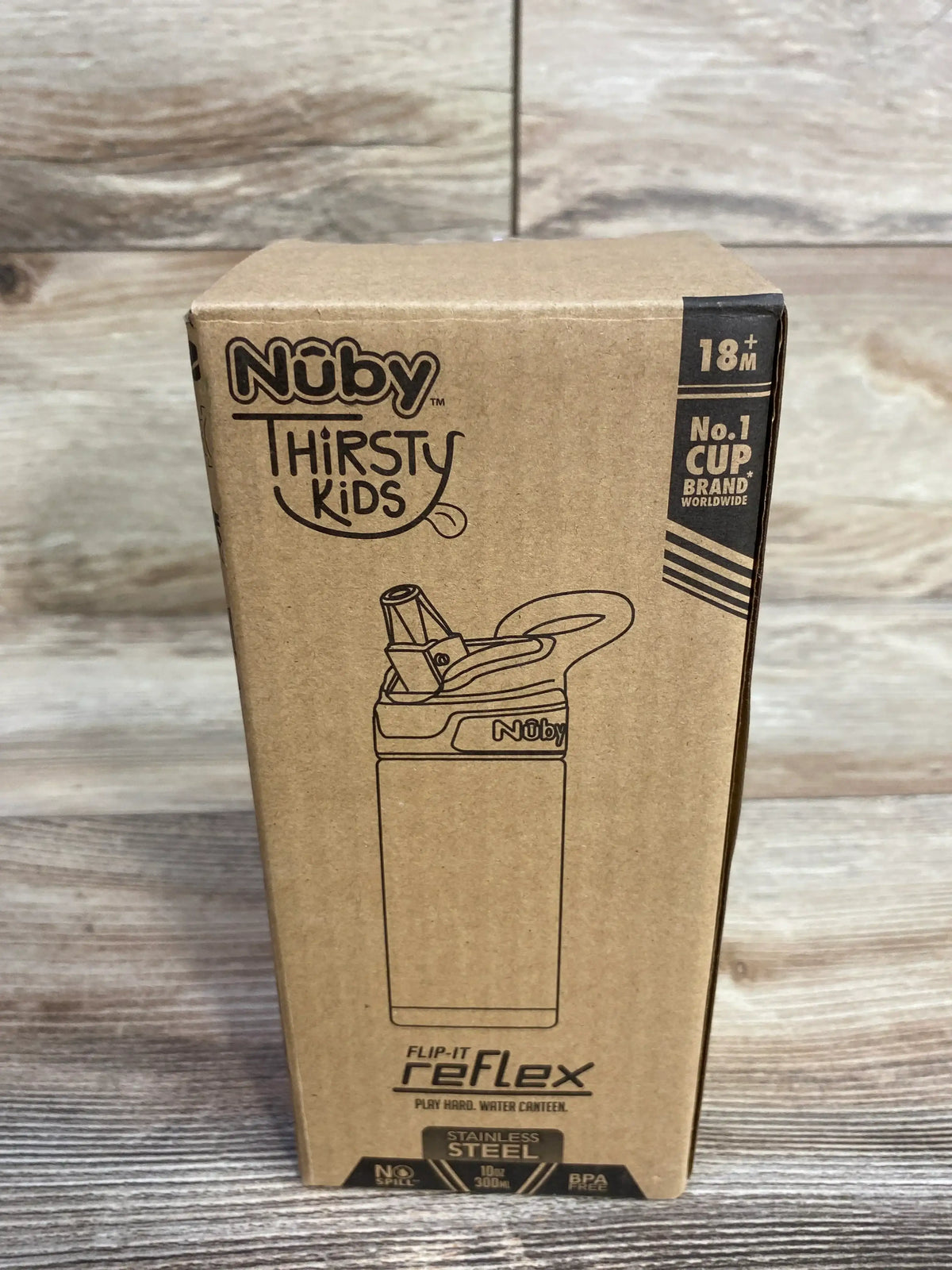 Front view of Nuby Thirsty Kids Flip-It Reflex 10 oz stainless steel cup box showcasing flip straw lid illustration with wood plank background