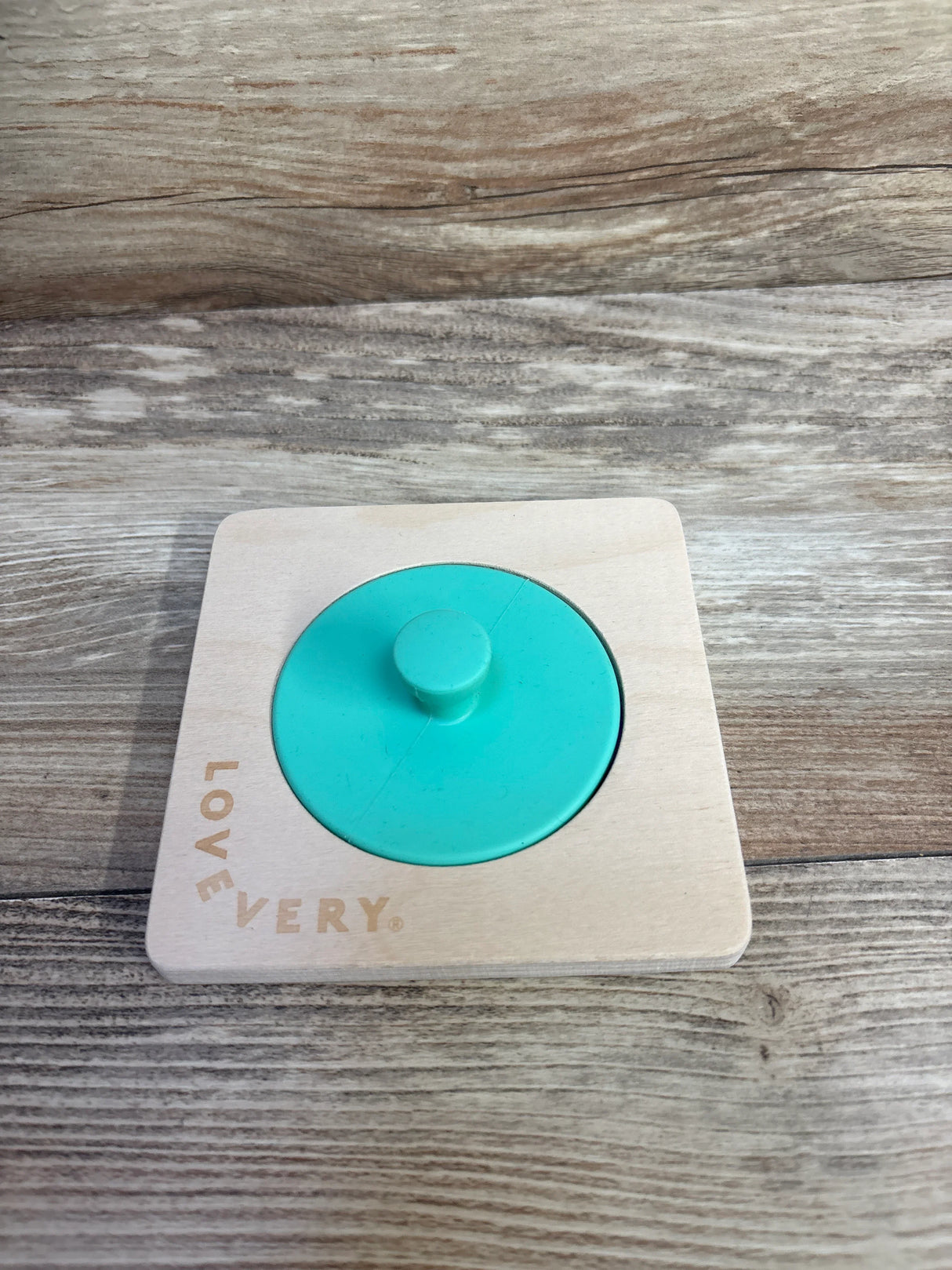 LOVEVERY wooden Montessori puzzle with teal knob on wood background
