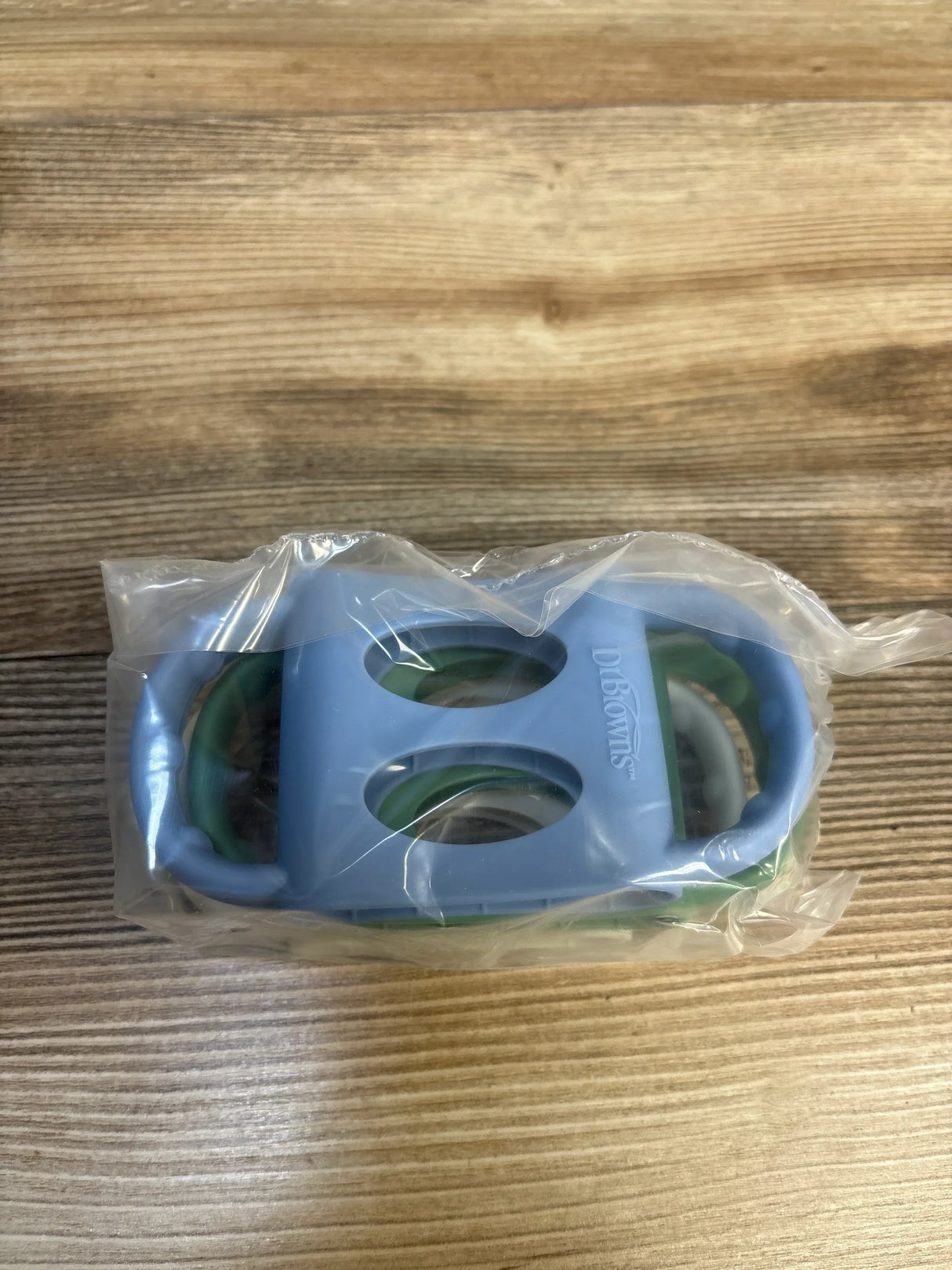 Dr. Brown's baby teething toy in blue and green, new in packaging on wood surface