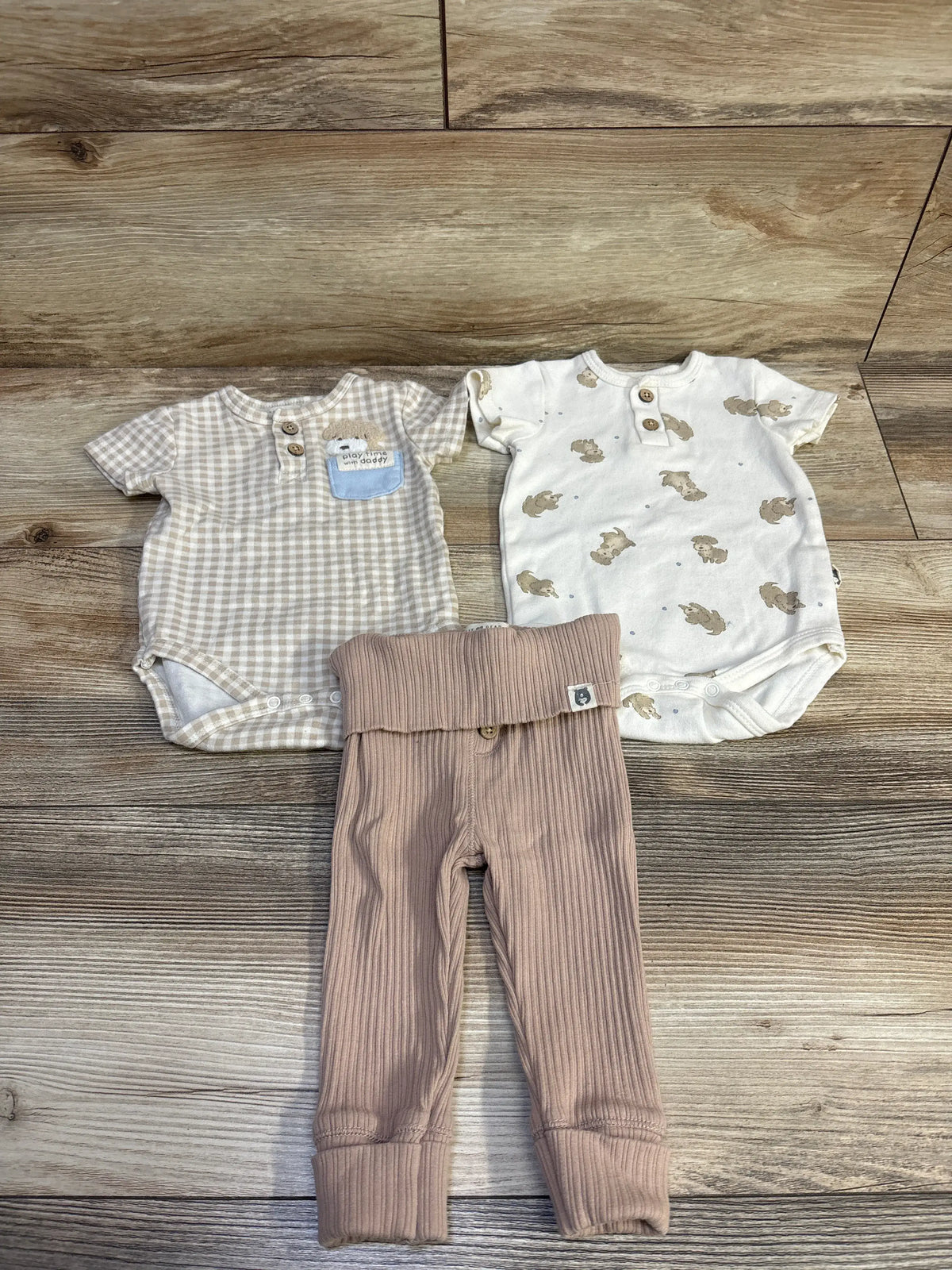 Top view of Rabbit + Bear 3pc Henley bodysuits and pant set, ivory, with checked and bunny-print bodysuits and ribbed pants