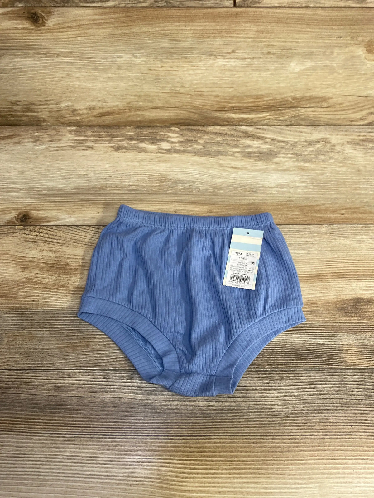 Flat lay of Cat & Jack blue ribbed baby bloomers (18M) showing elastic waistband and attached tag on light wood background