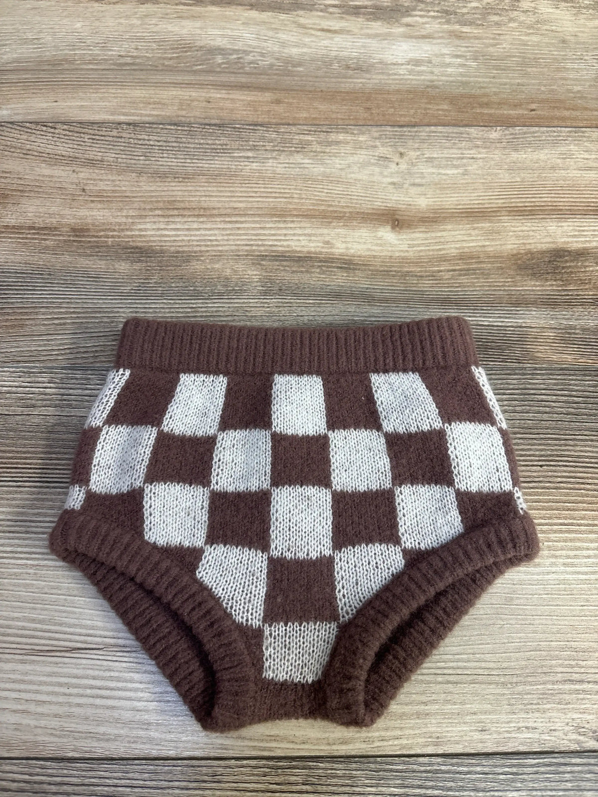 Flat lay of Rylee + Cru sweater bloomers, brown and cream checker knit with ribbed waist and leg cuffs on wood table