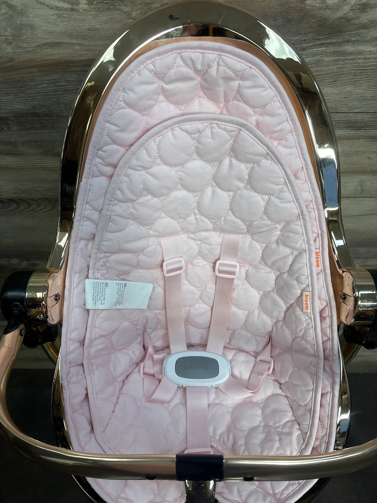 Top view of Bloom Fresco Special Edition High Chair in Rose Gold showcasing padded five-point harness on a wood floor