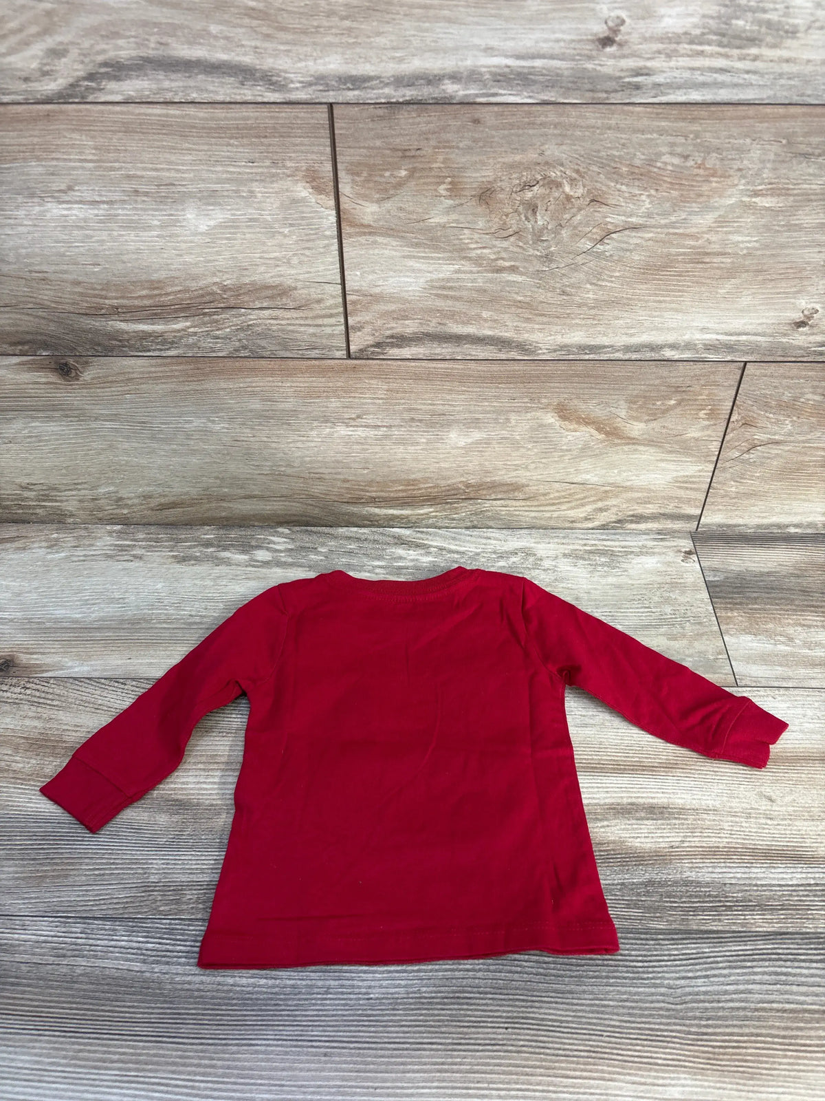 Back view of NWOT Tommy Hilfiger Make Today Epic shirt in red, showing a plain back on a wood-look floor
