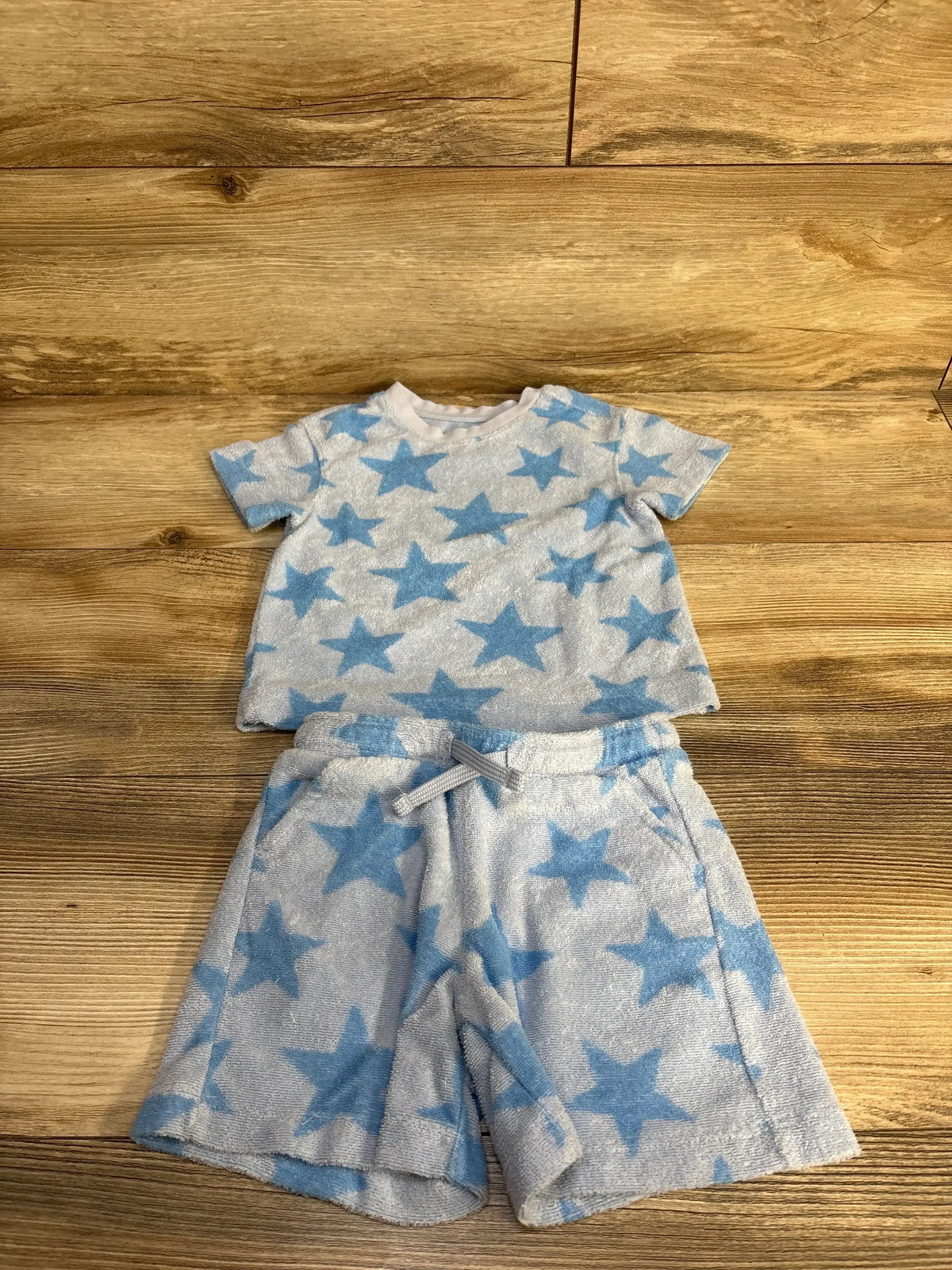 Flat lay of Cat & Jack blue terry cloth two-piece shirt and shorts set showcasing blue star print on wood background