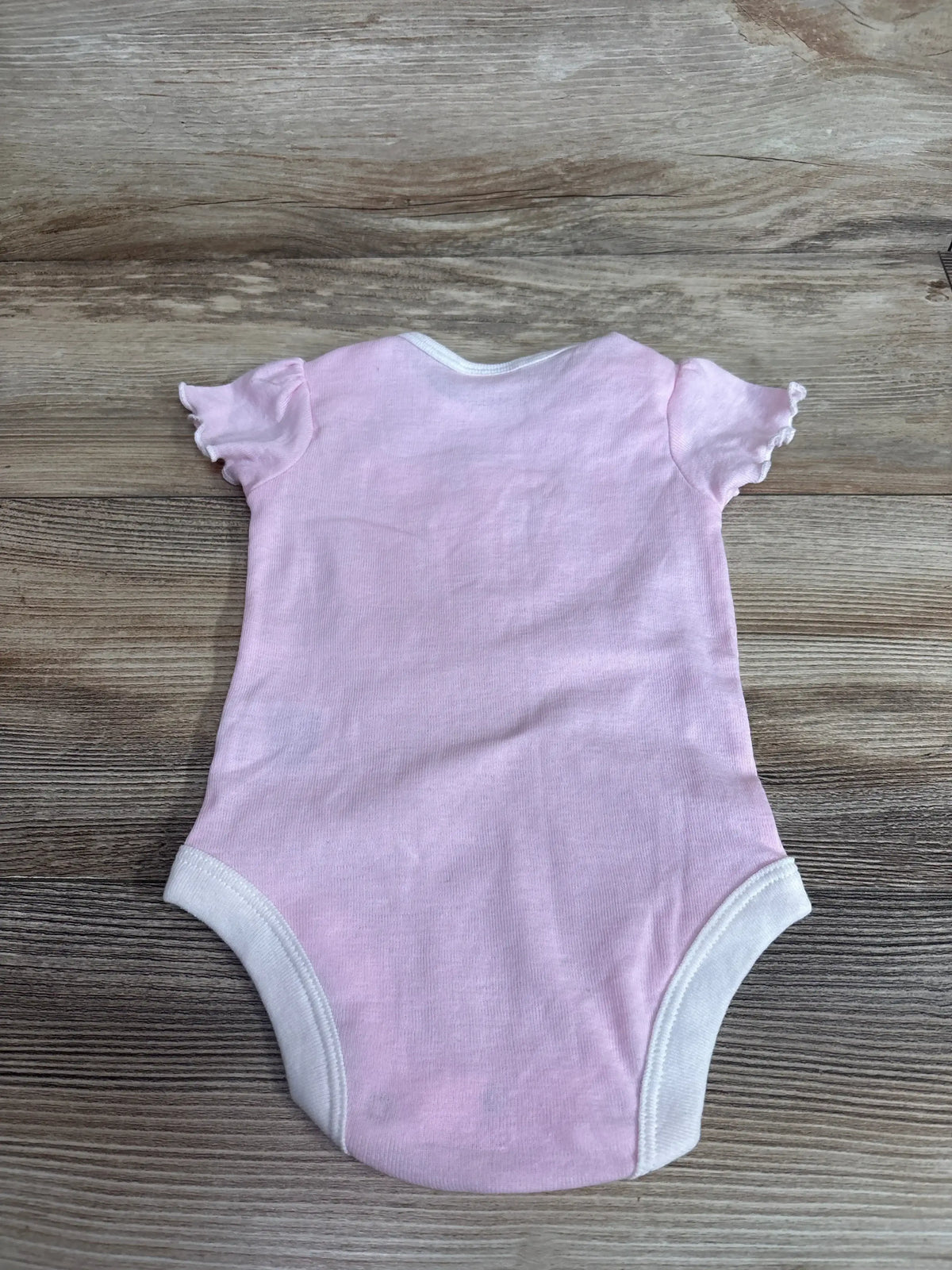 Back view of Rivalry Threads UNLV Love Rebels bodysuit size 3-6m in pink with ruffle sleeves and white trim on wood plank floor